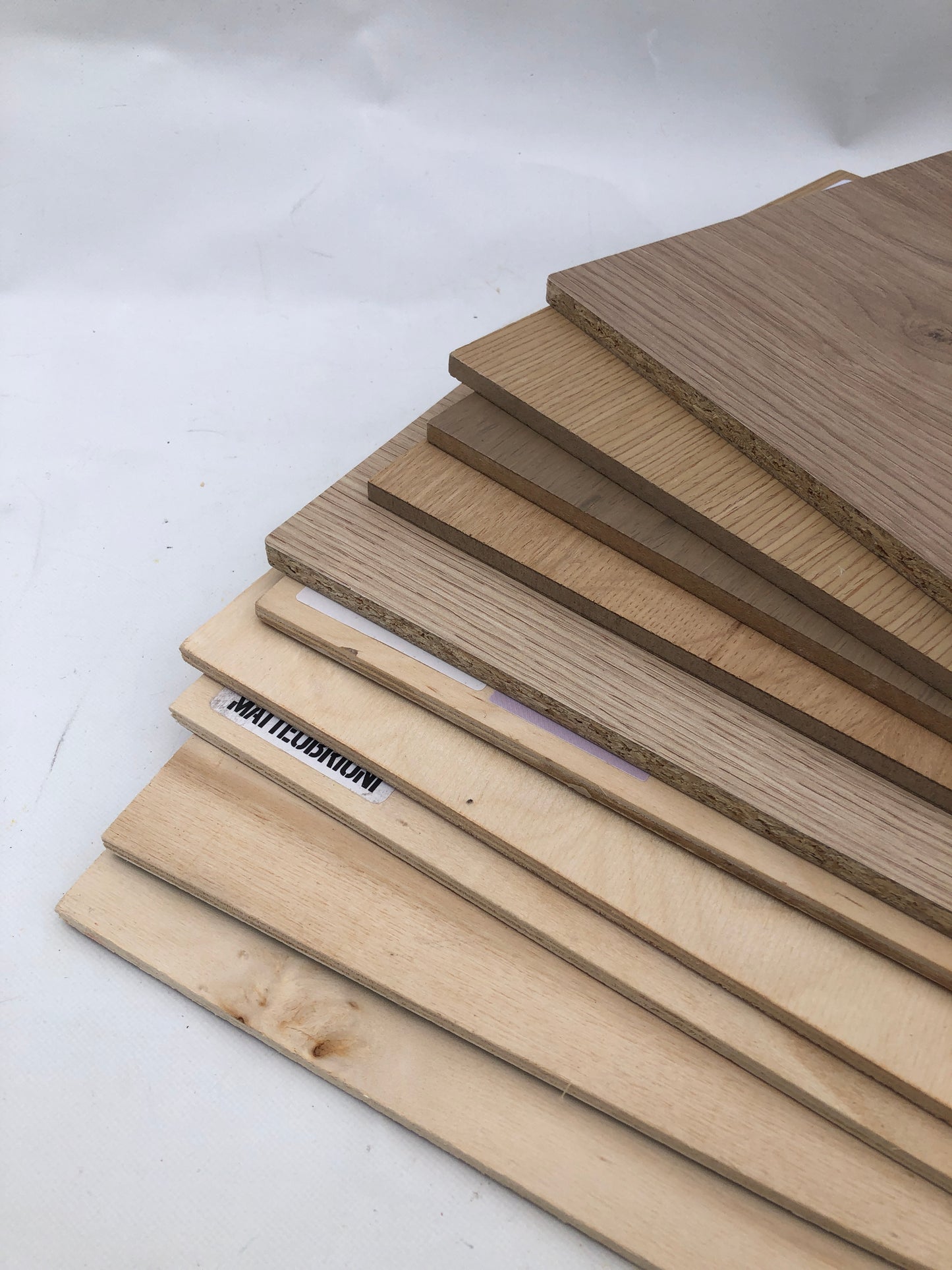 Wood panels are arranged in a tidy stack on a white background