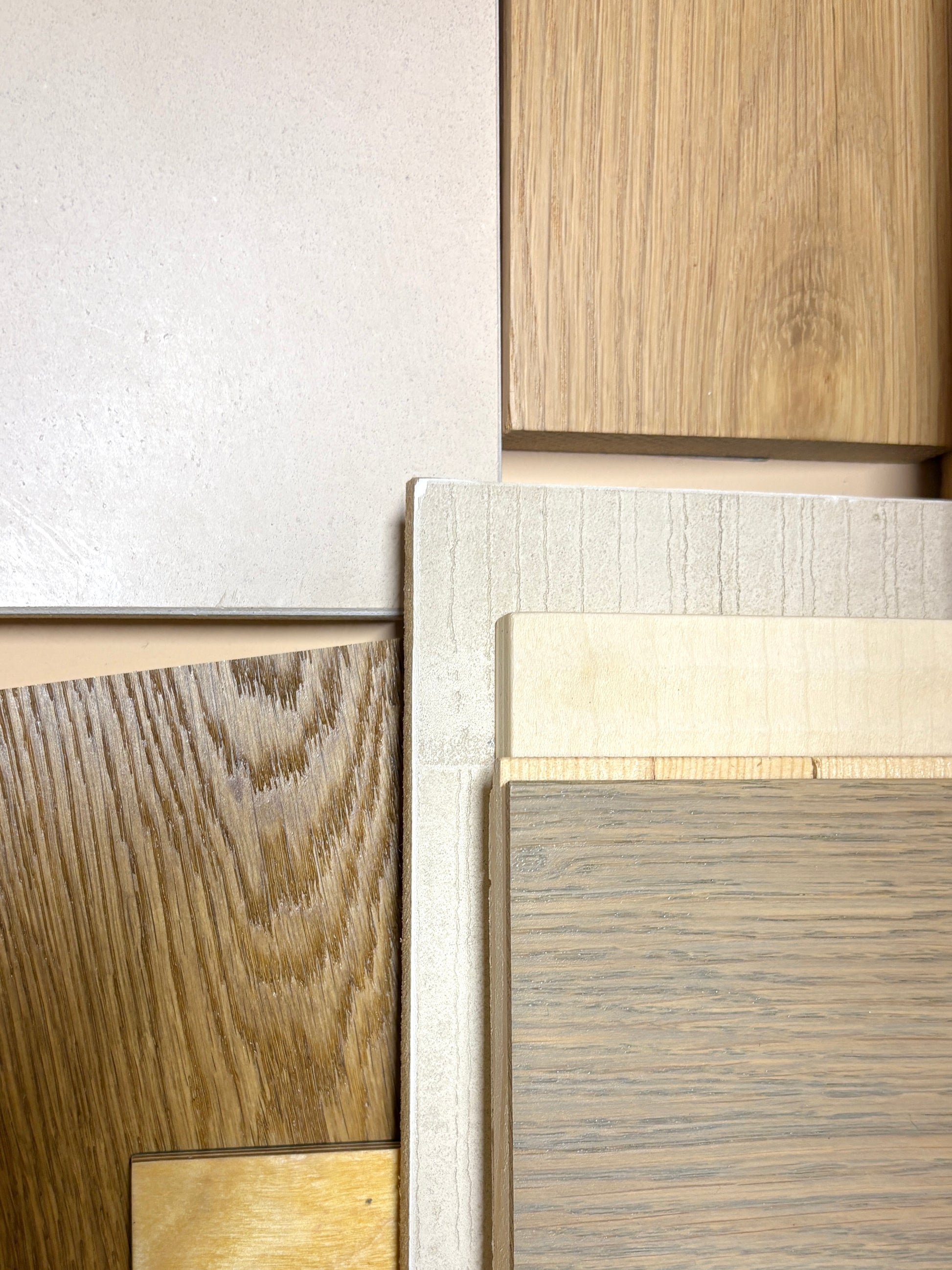 Close-up of wooden panels with different finishes on a neutral background