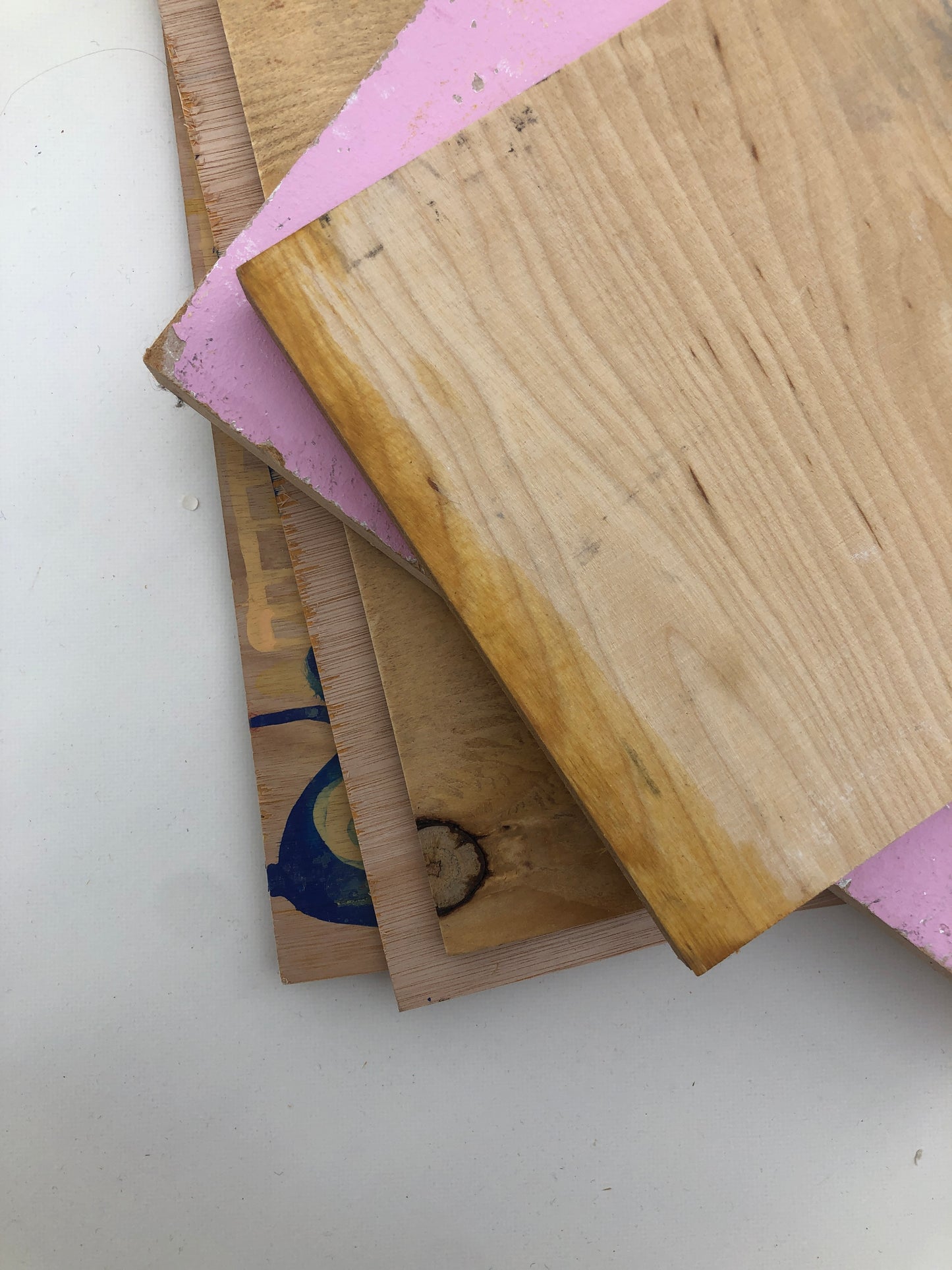 Small wood sample boards are stacked on a white background