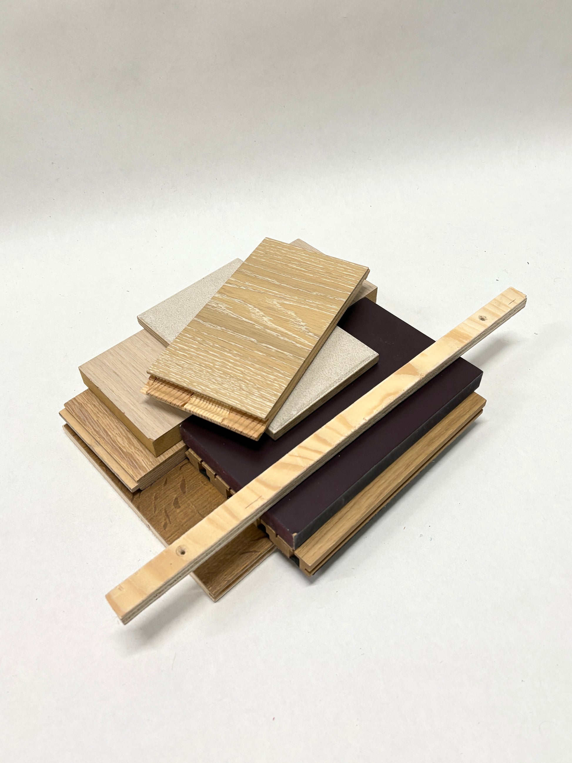     Wood sample pieces and narrow strips are arranged in a loose stack