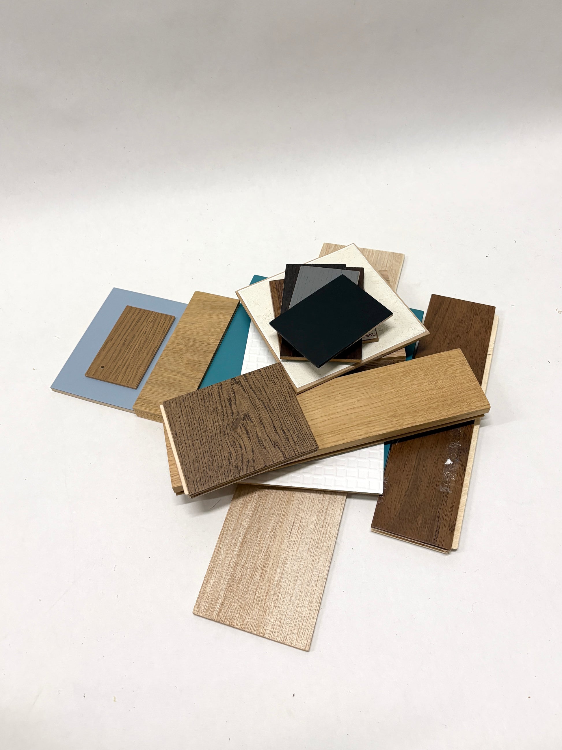     Assorted wood-effect and coloured sample boards are spread on white