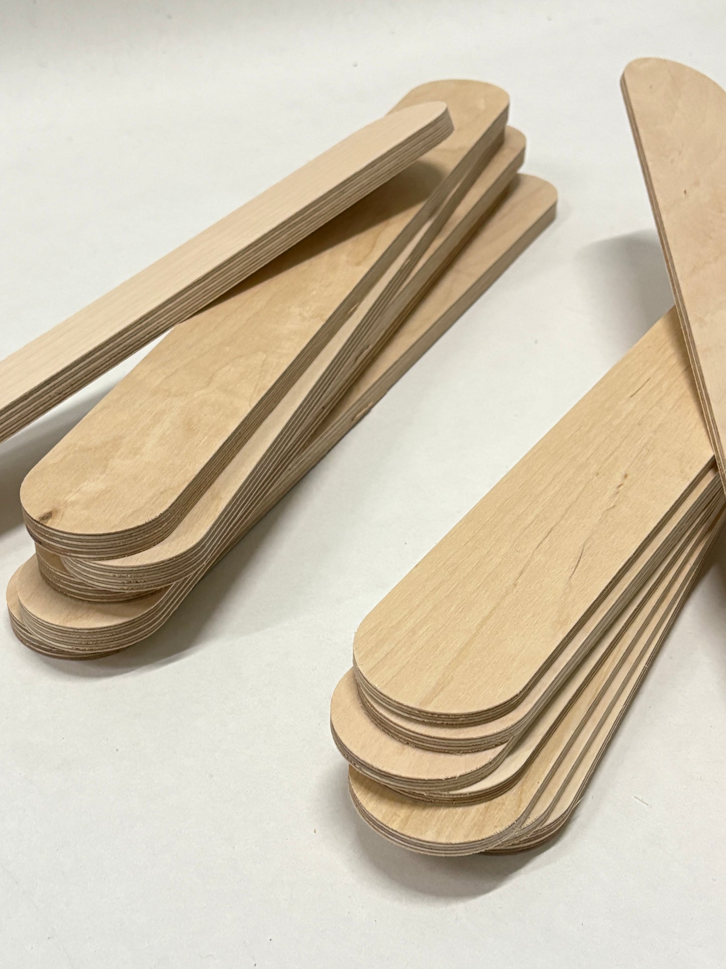 Layered plywood strips with rounded wooden sticks on a white background.