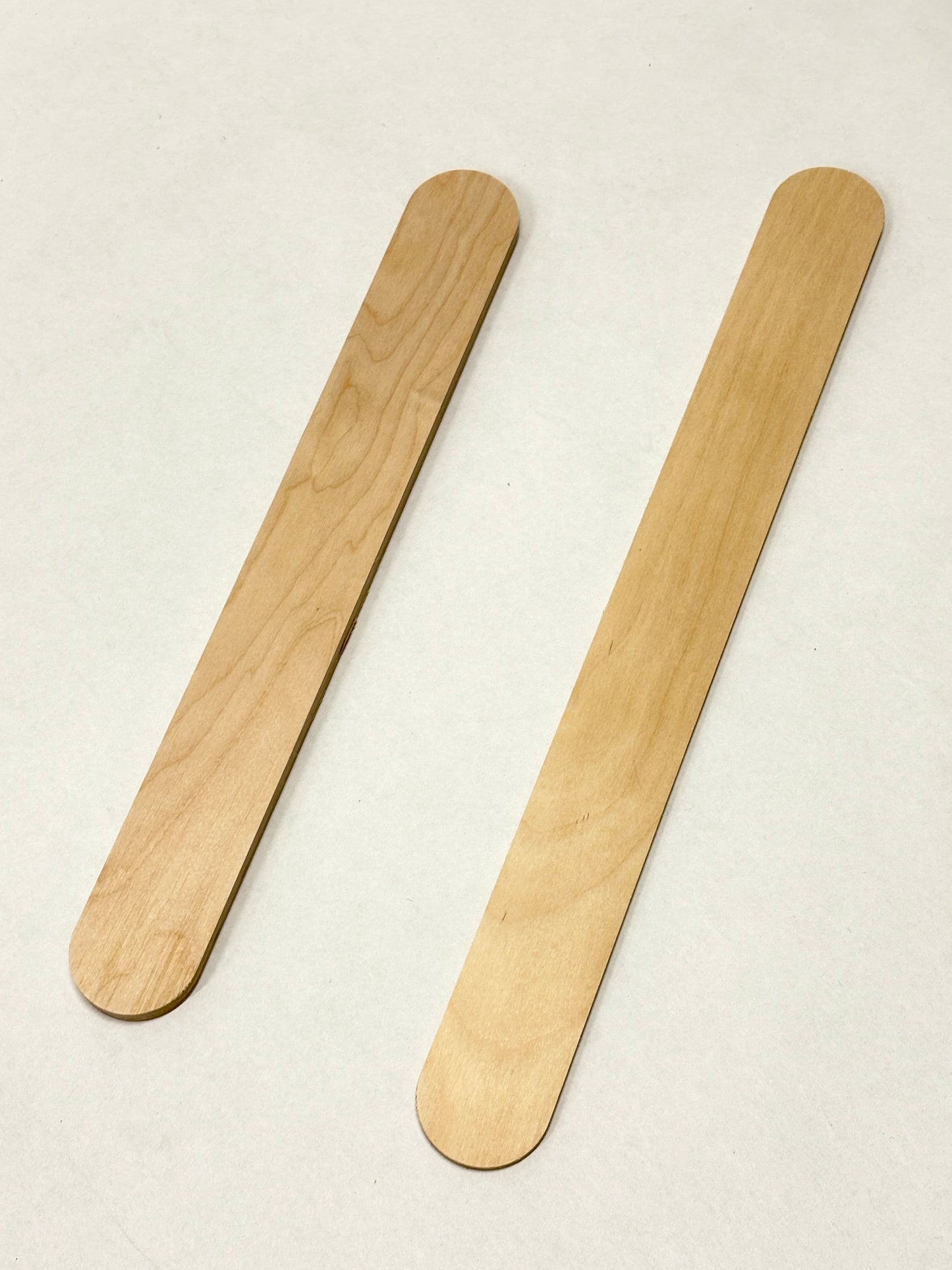 Two rounded wooden sticks displayed on a white background.
