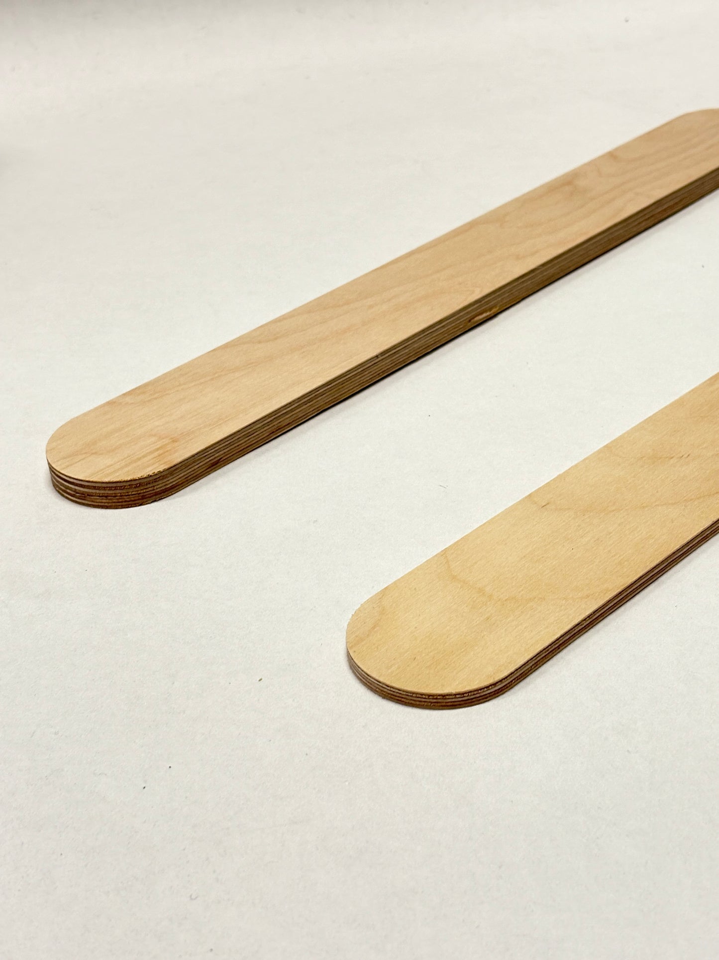 Close-up of two rounded wooden sticks on a white background.