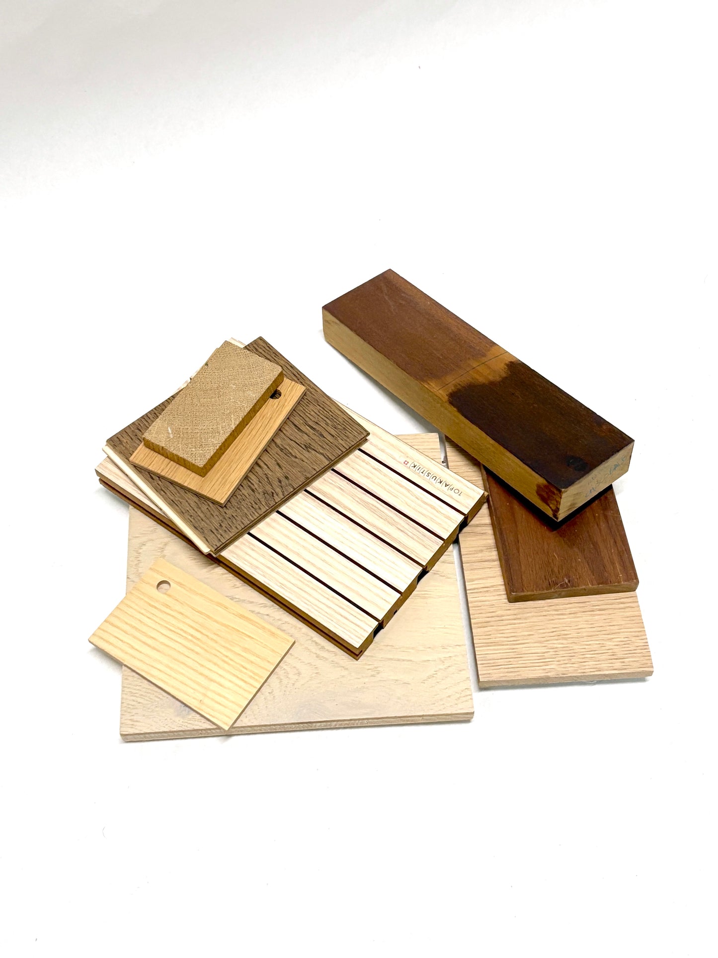 Mixed wood sample pieces are arranged on a white background