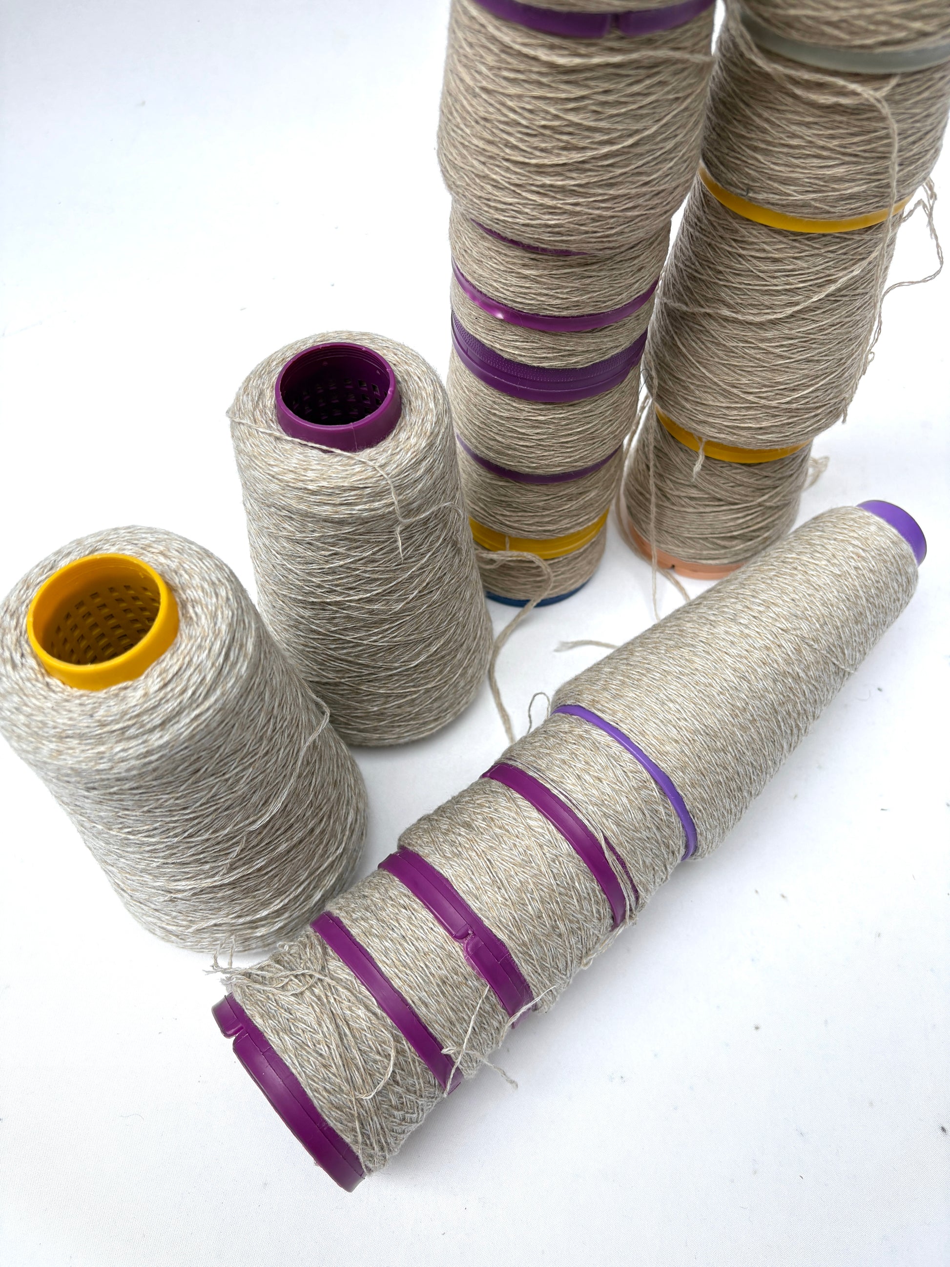 Off-white thread spools are grouped in upright and horizontal positions