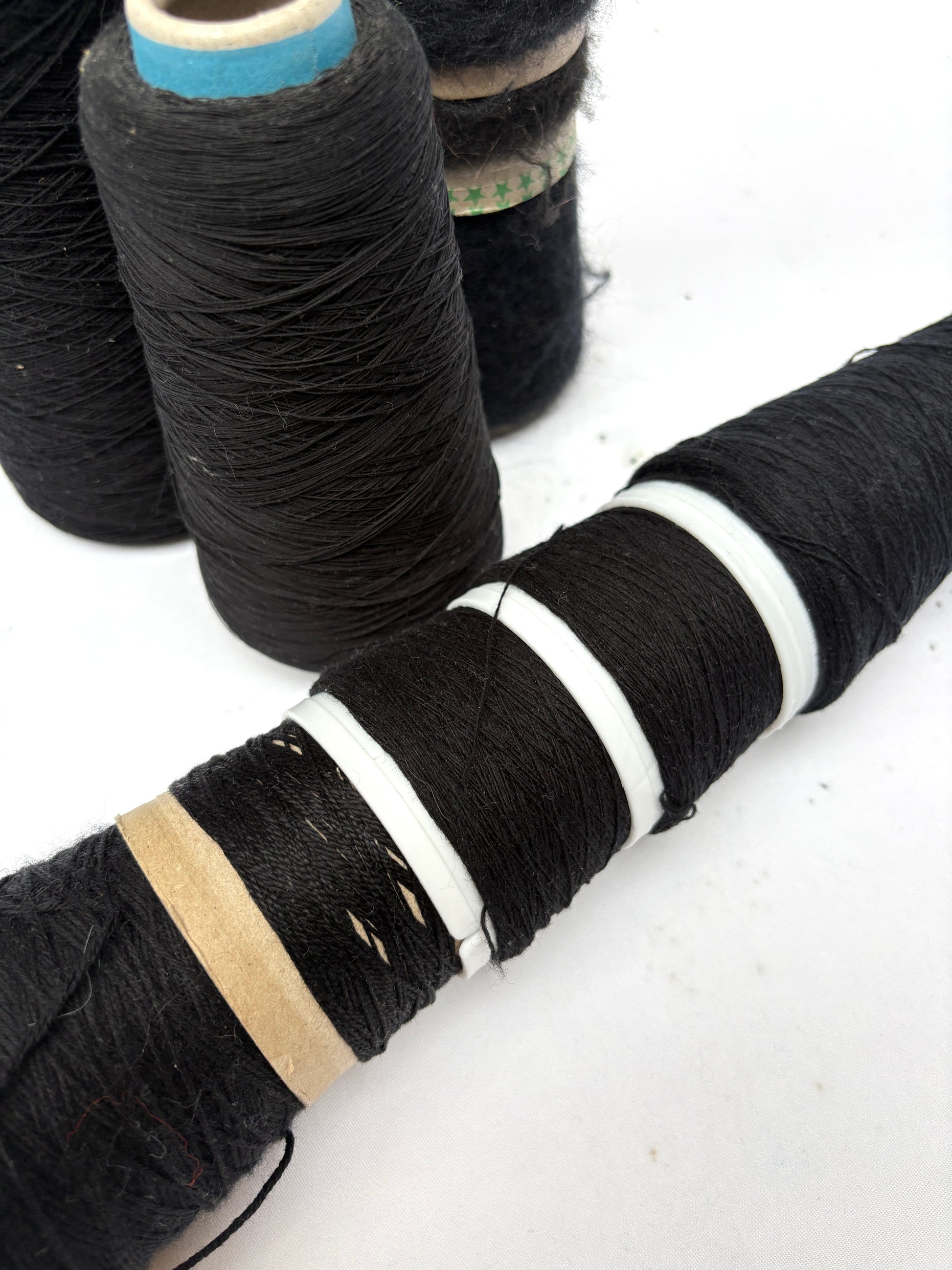 Black thread spools are shown in mixed upright and side views
