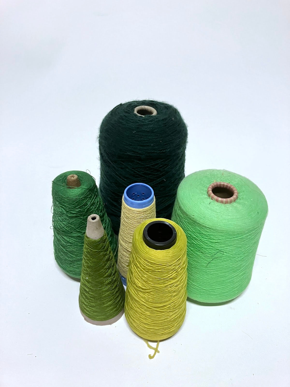 Green thread spools are displayed in a small group
