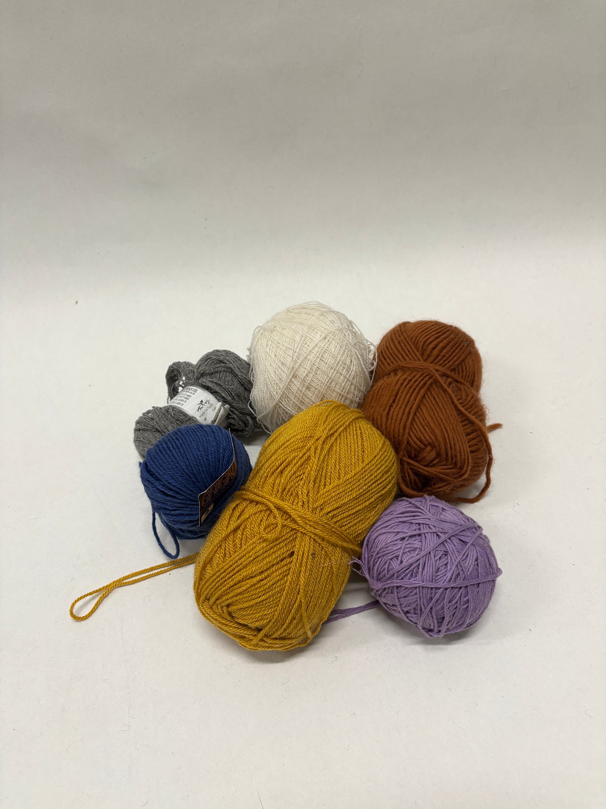 Mixed yarn balls are grouped on a white background