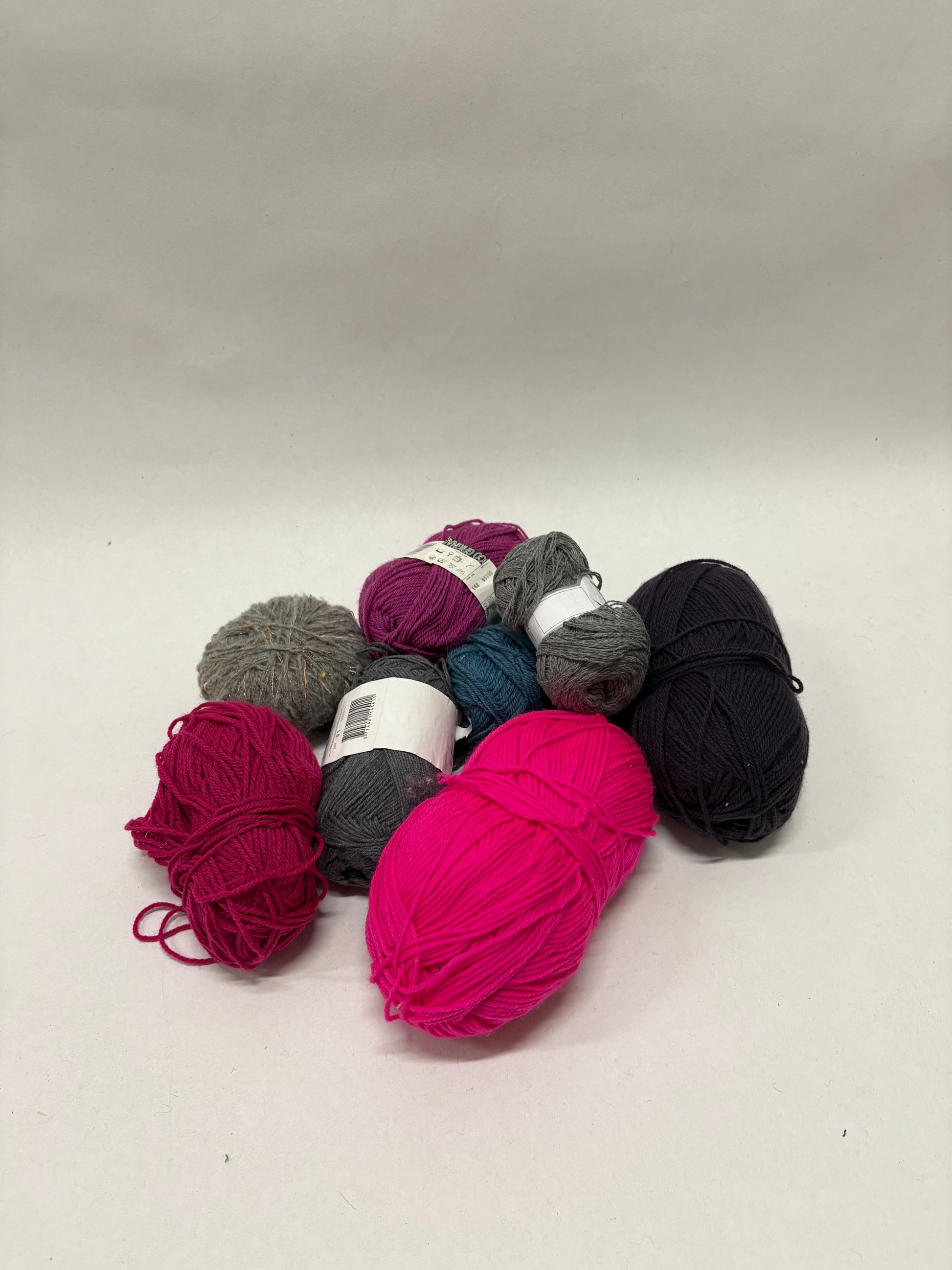Assorted yarn in different colours is arranged in a loose pile