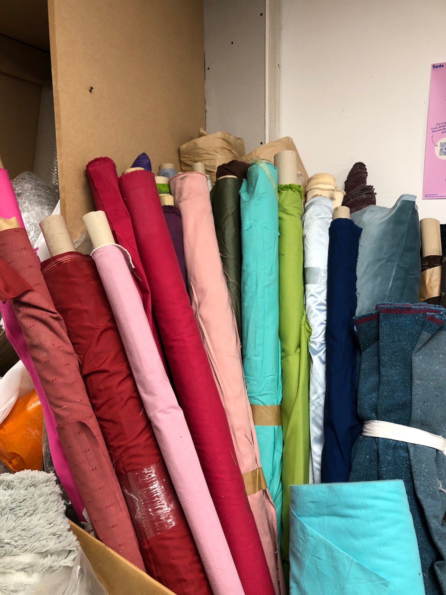 Stack of rolls of colourful fabric