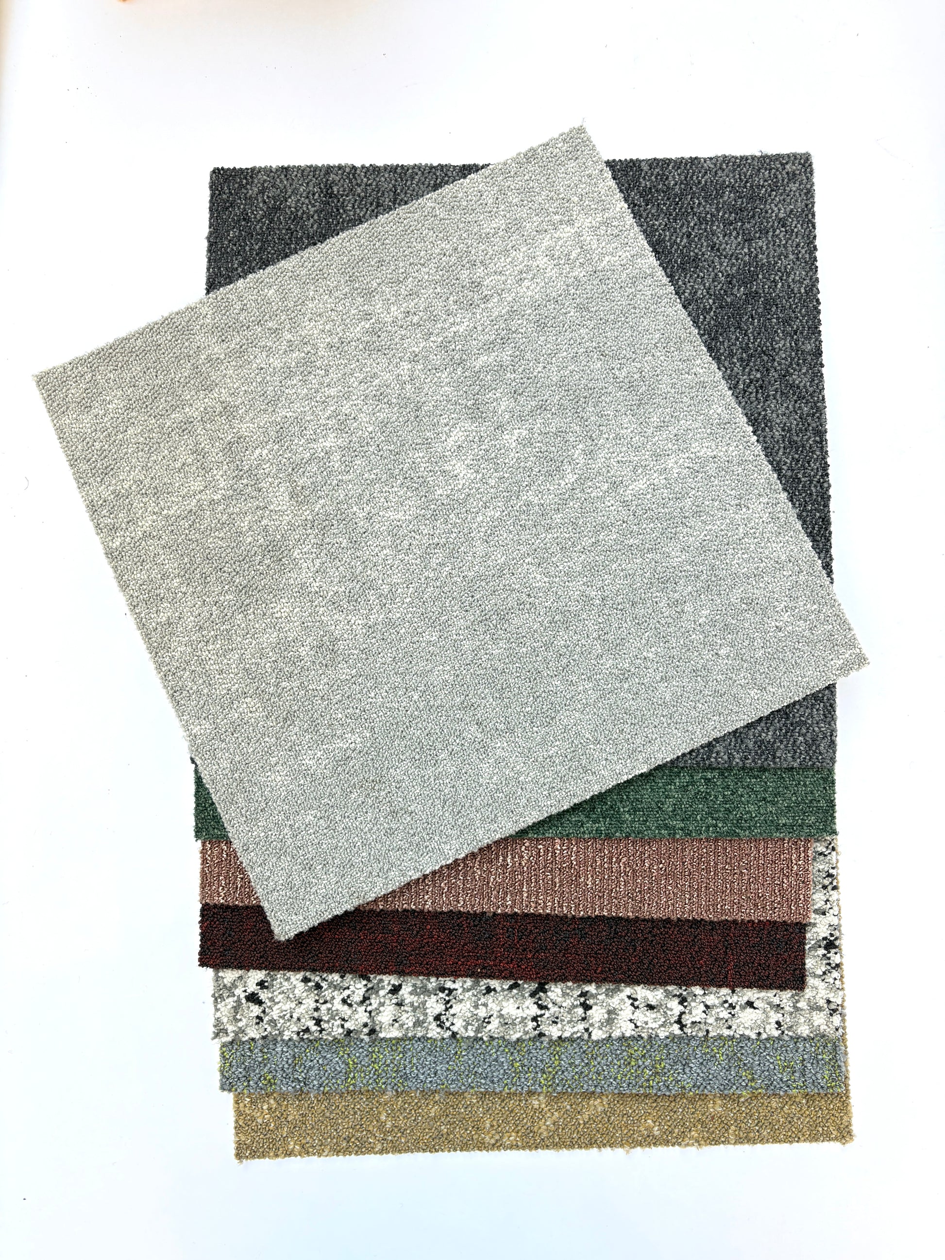 Collection of large square pieces of carpet samples in various colours 