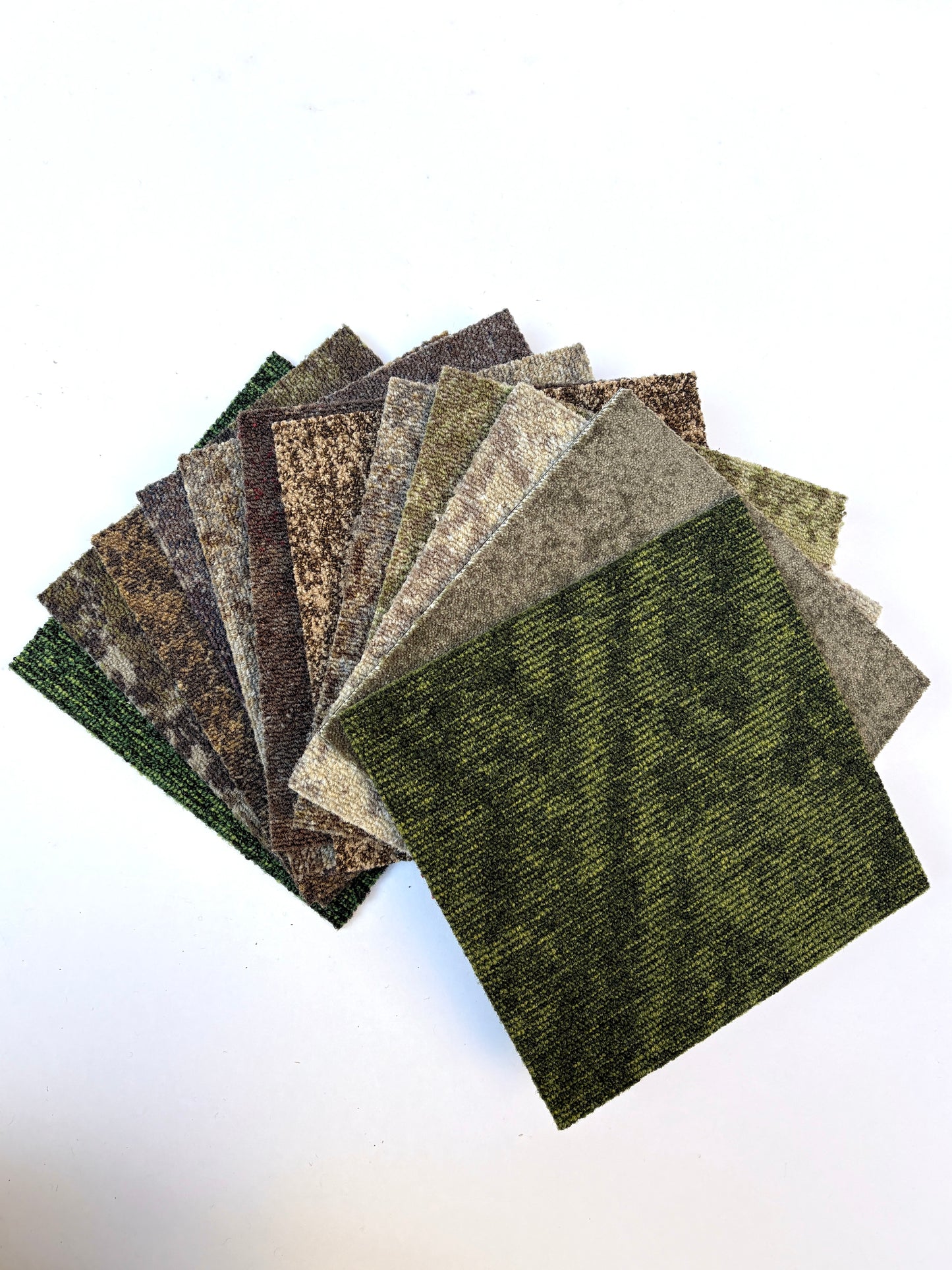 Square sample boards are stacked with one light grey piece on top