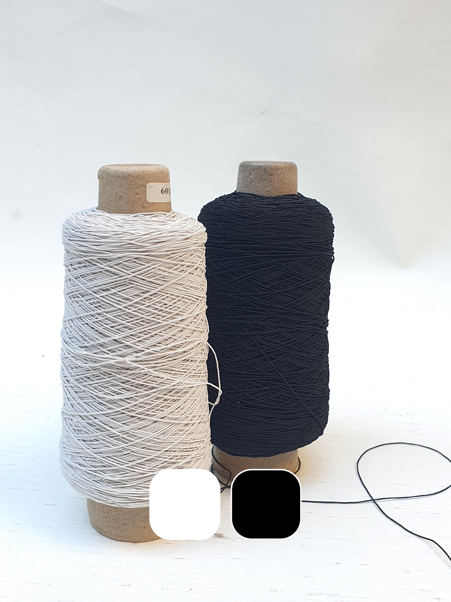 Two elastic cord rolls in black and white with colour swatches below