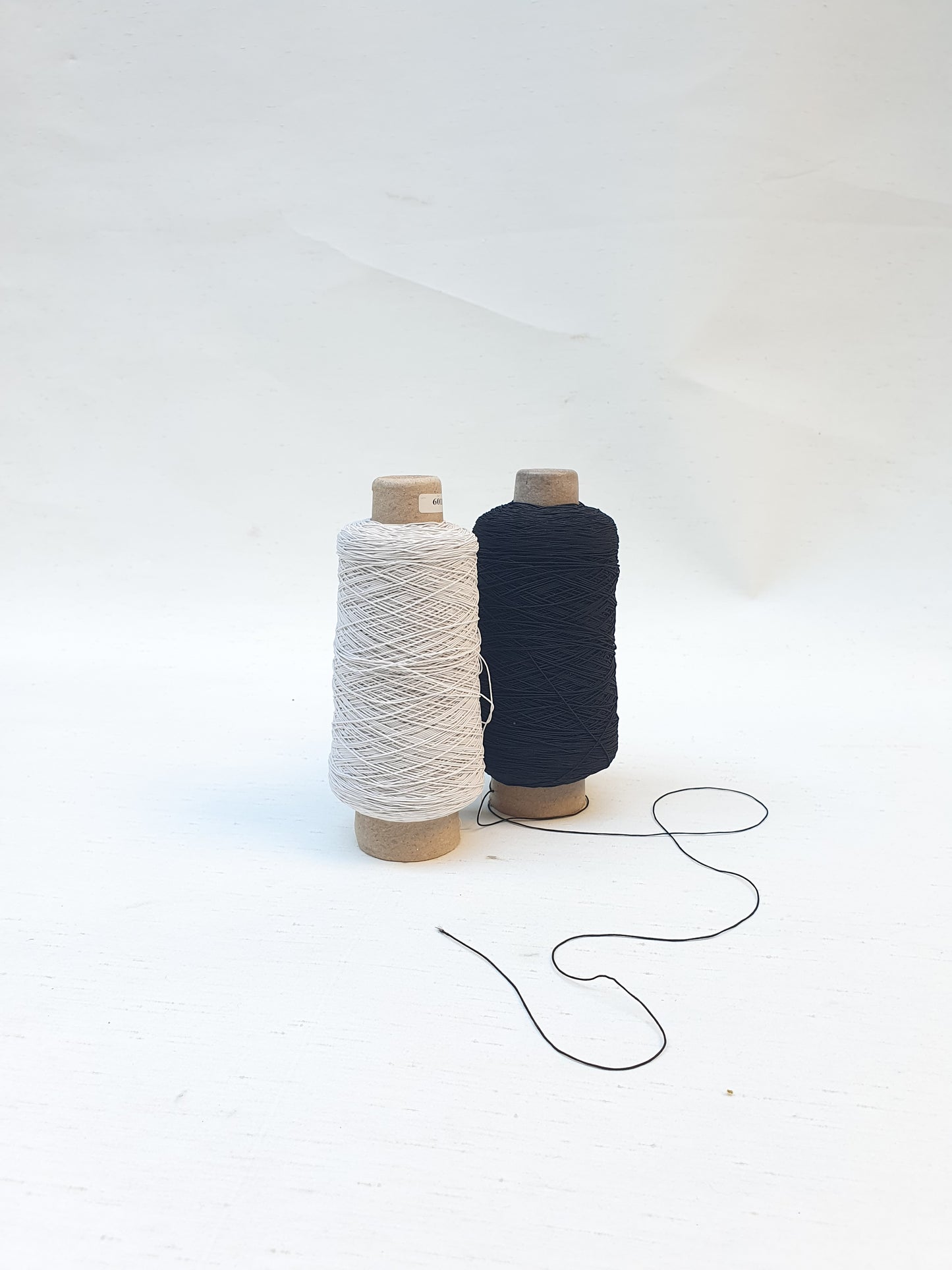 Two elastic cord rolls in black and white 
