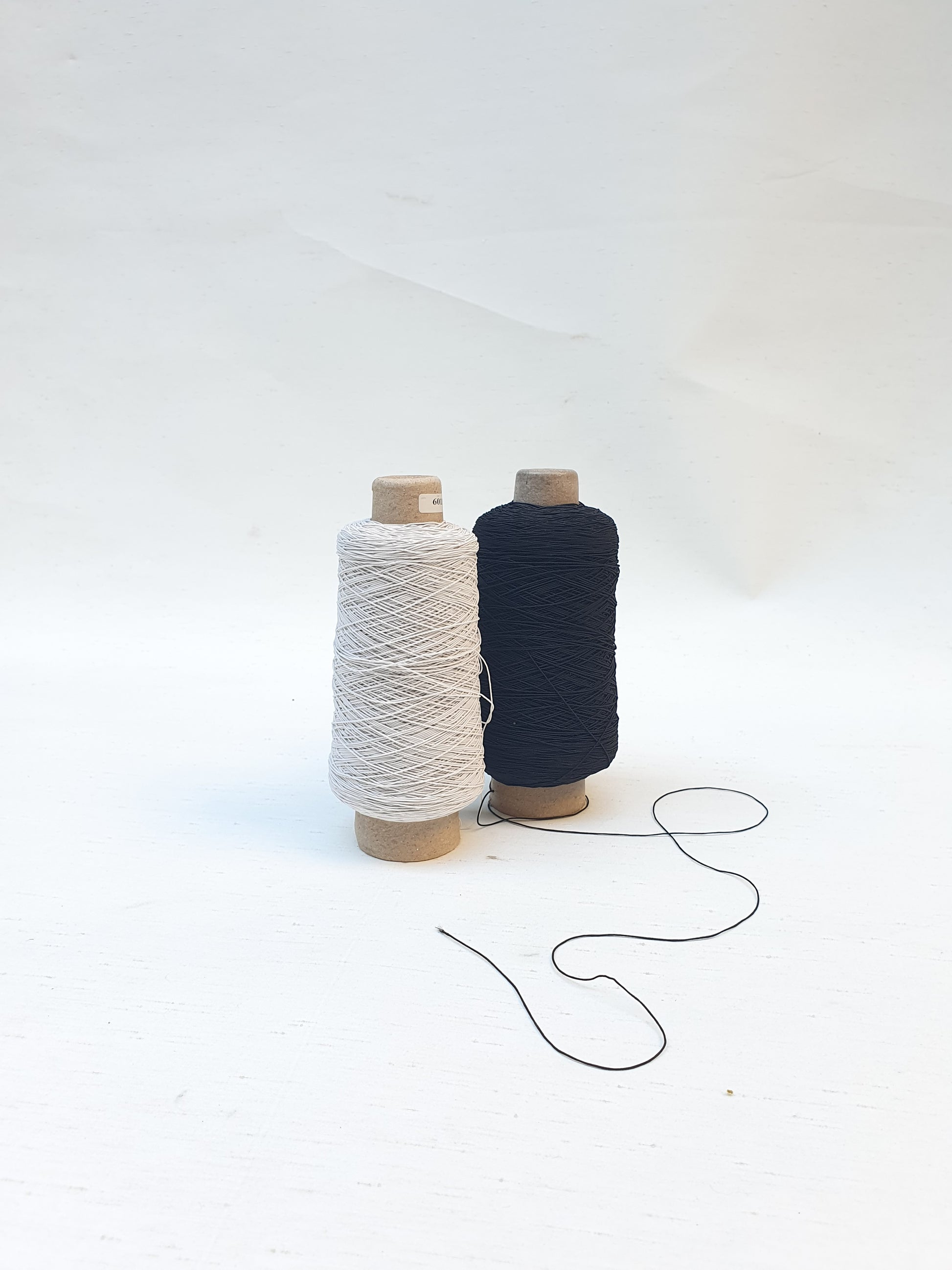 Two elastic cord rolls in black and white 