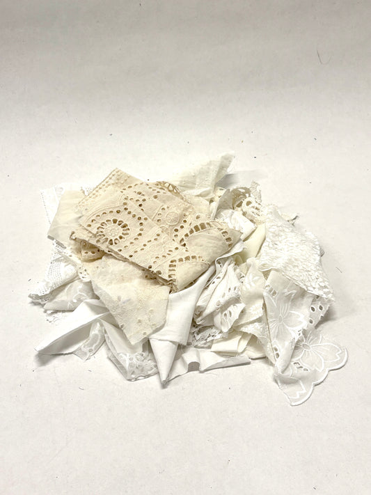 A pile of decorative lace textiles offcuts samples in white