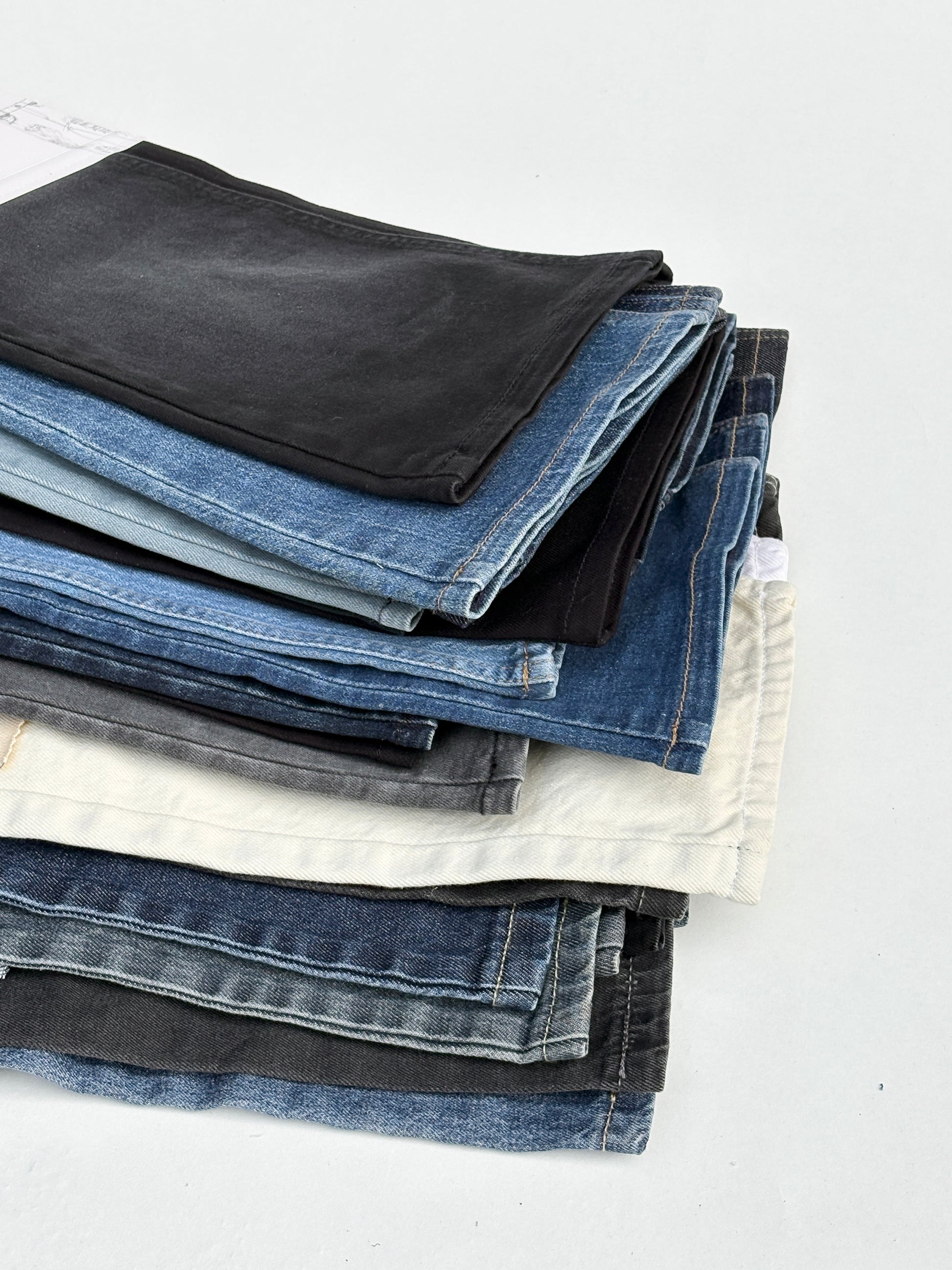 Stack of denim fabric samples with classic denim shades
