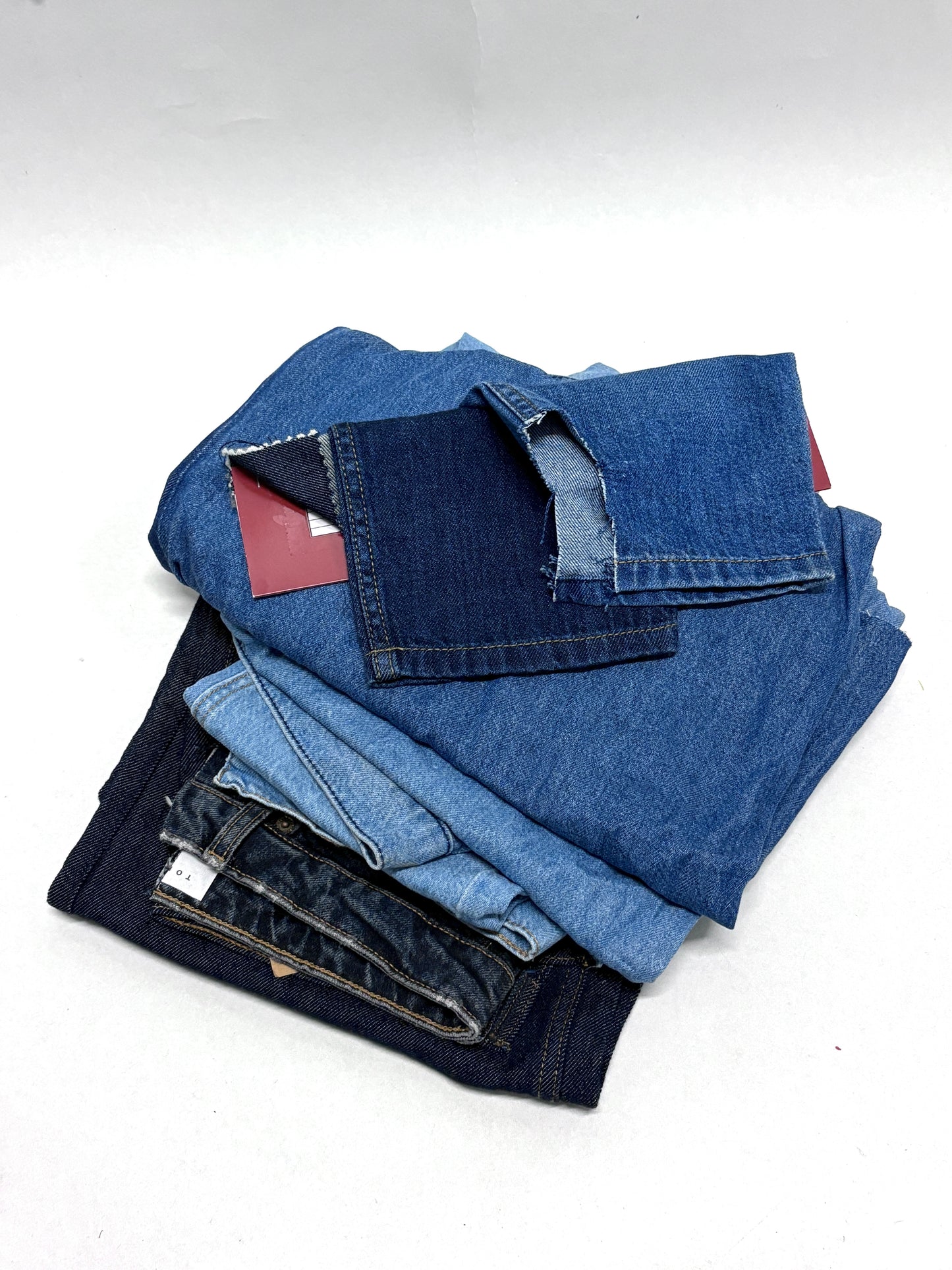 Stack of denim fabric samples with classic denim shades