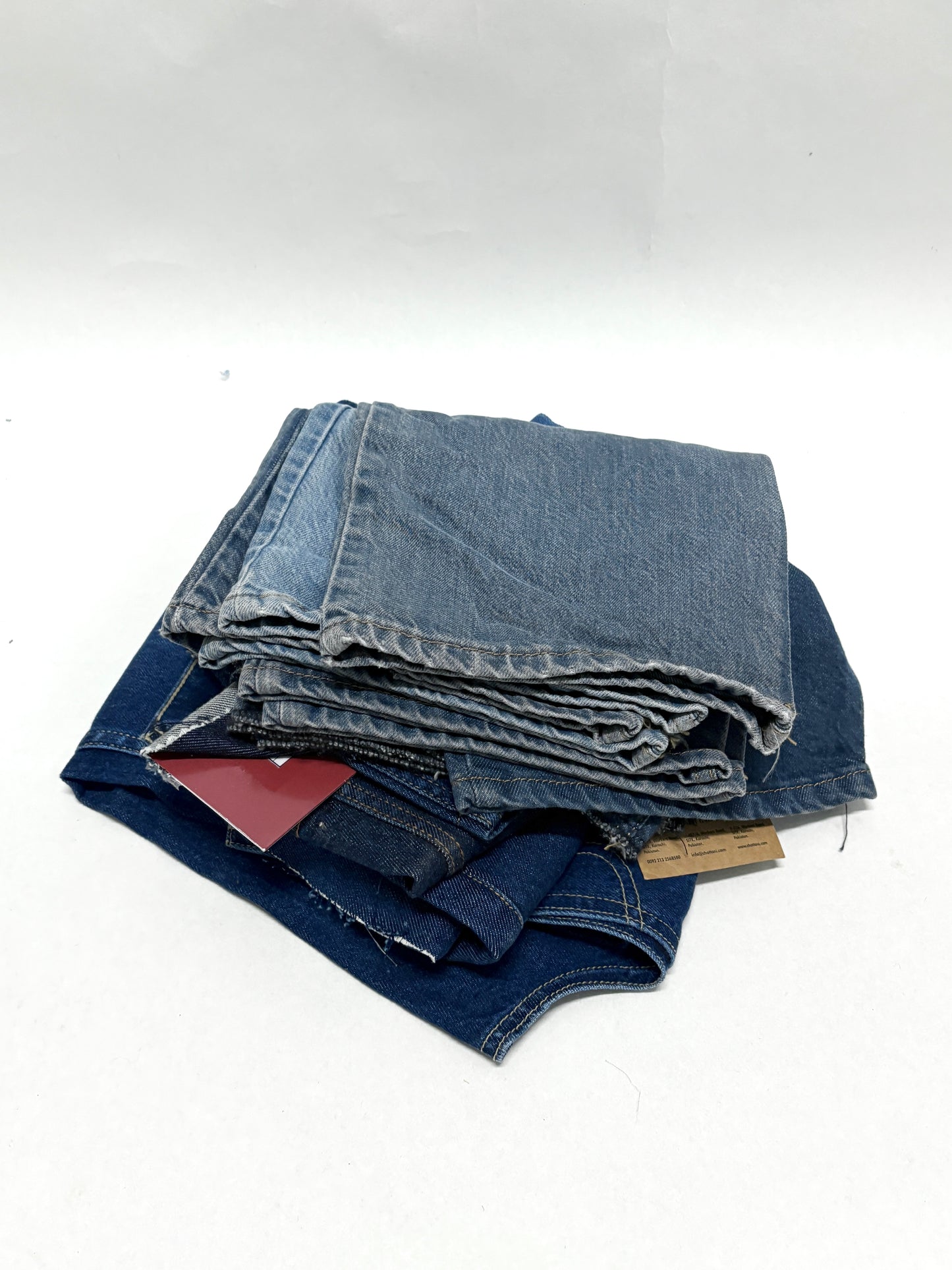 Stack of denim fabric samples with classic denim shades