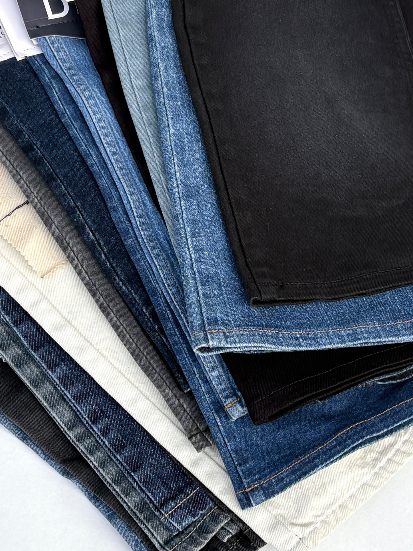 Stack of denim fabric samples with classic denim shades
