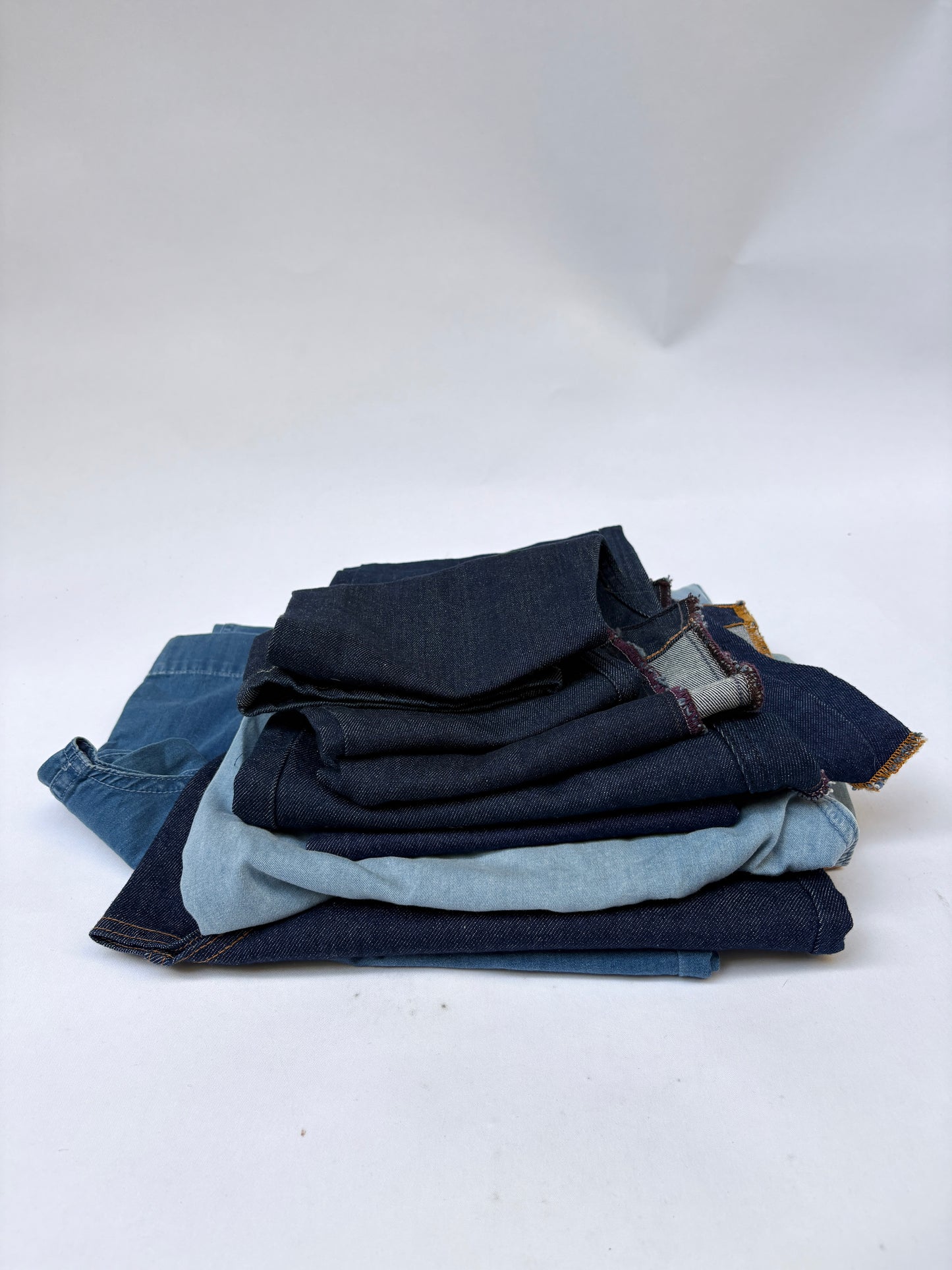 Stack of denim fabric samples with classic denim shades