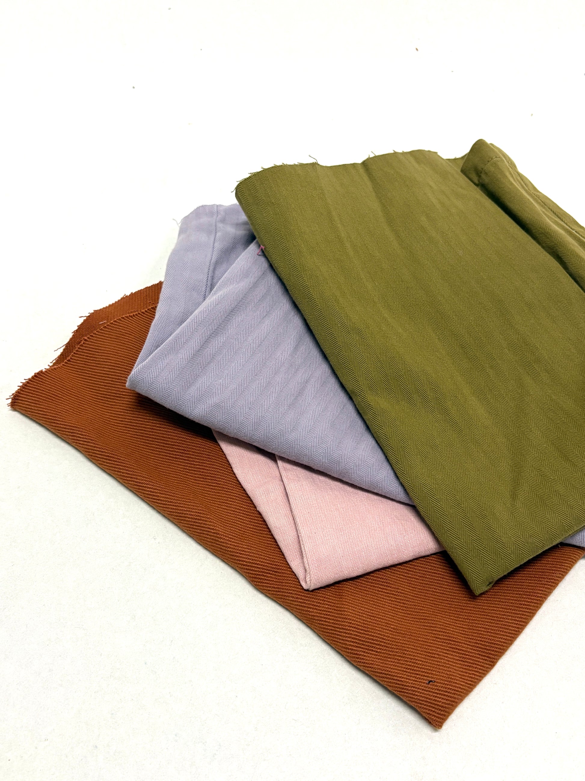 Stack of denim fabric samples in various colours 