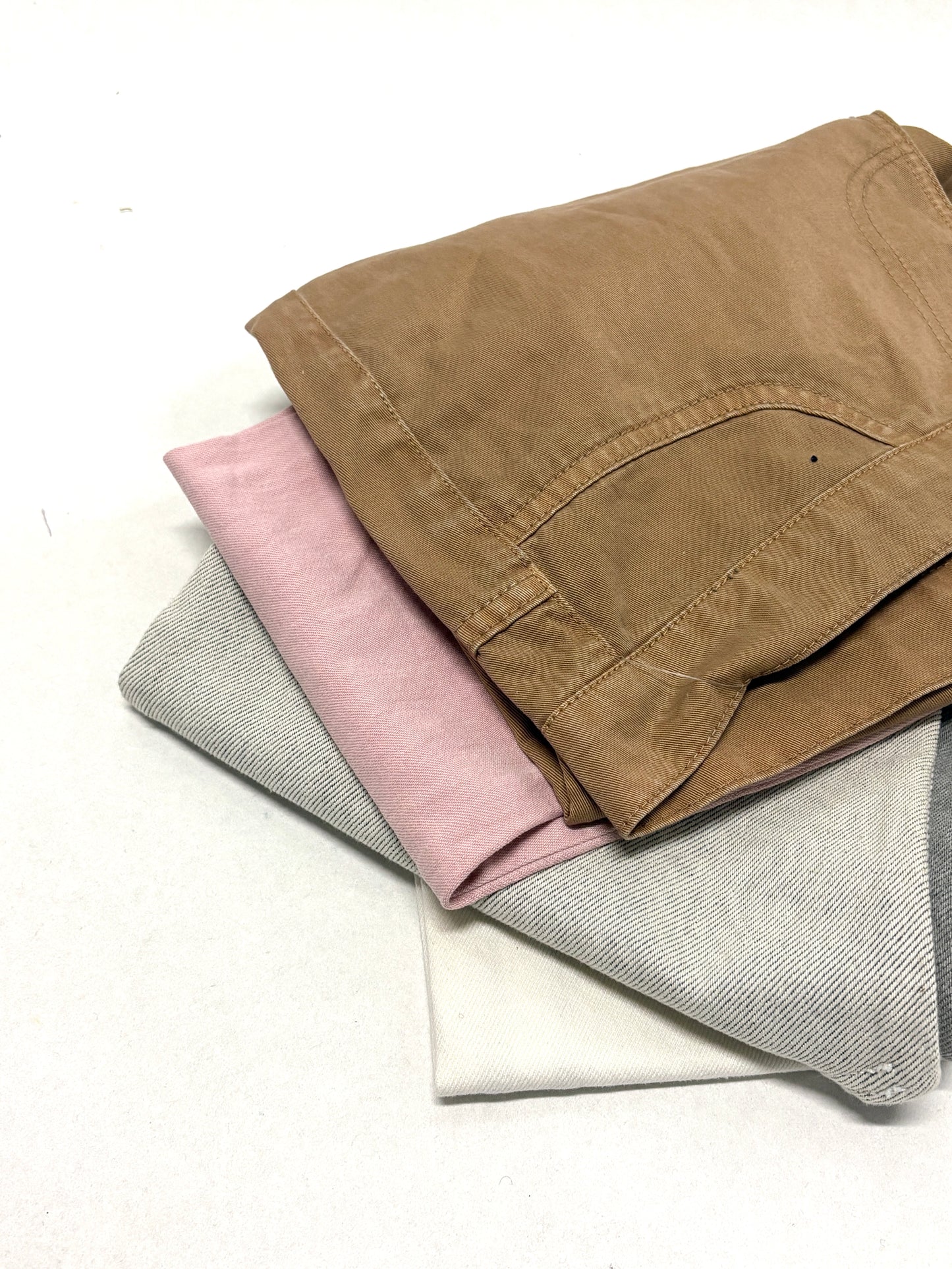 Stack of denim fabric samples in various colours 