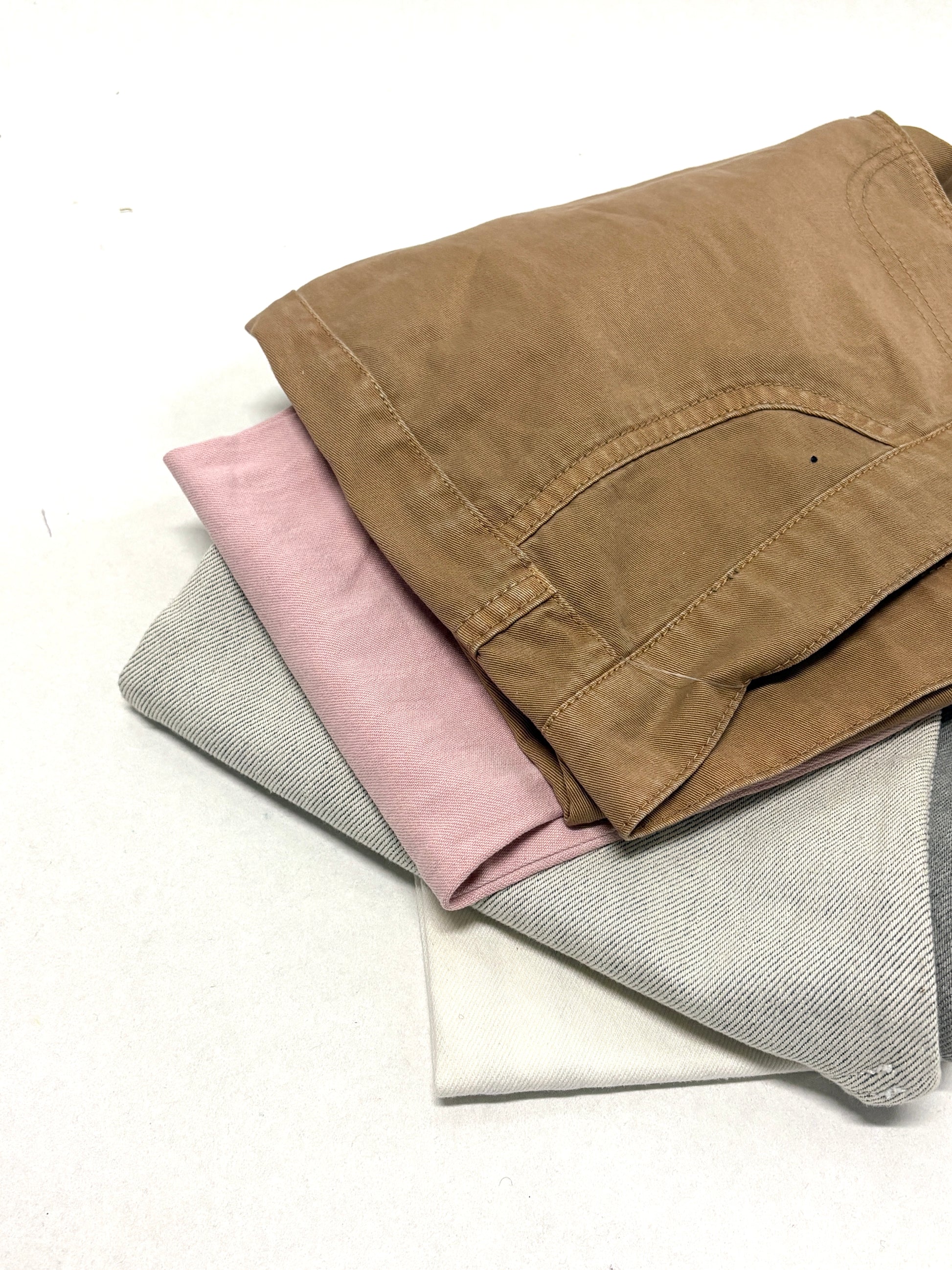 Stack of denim fabric samples in various colours 