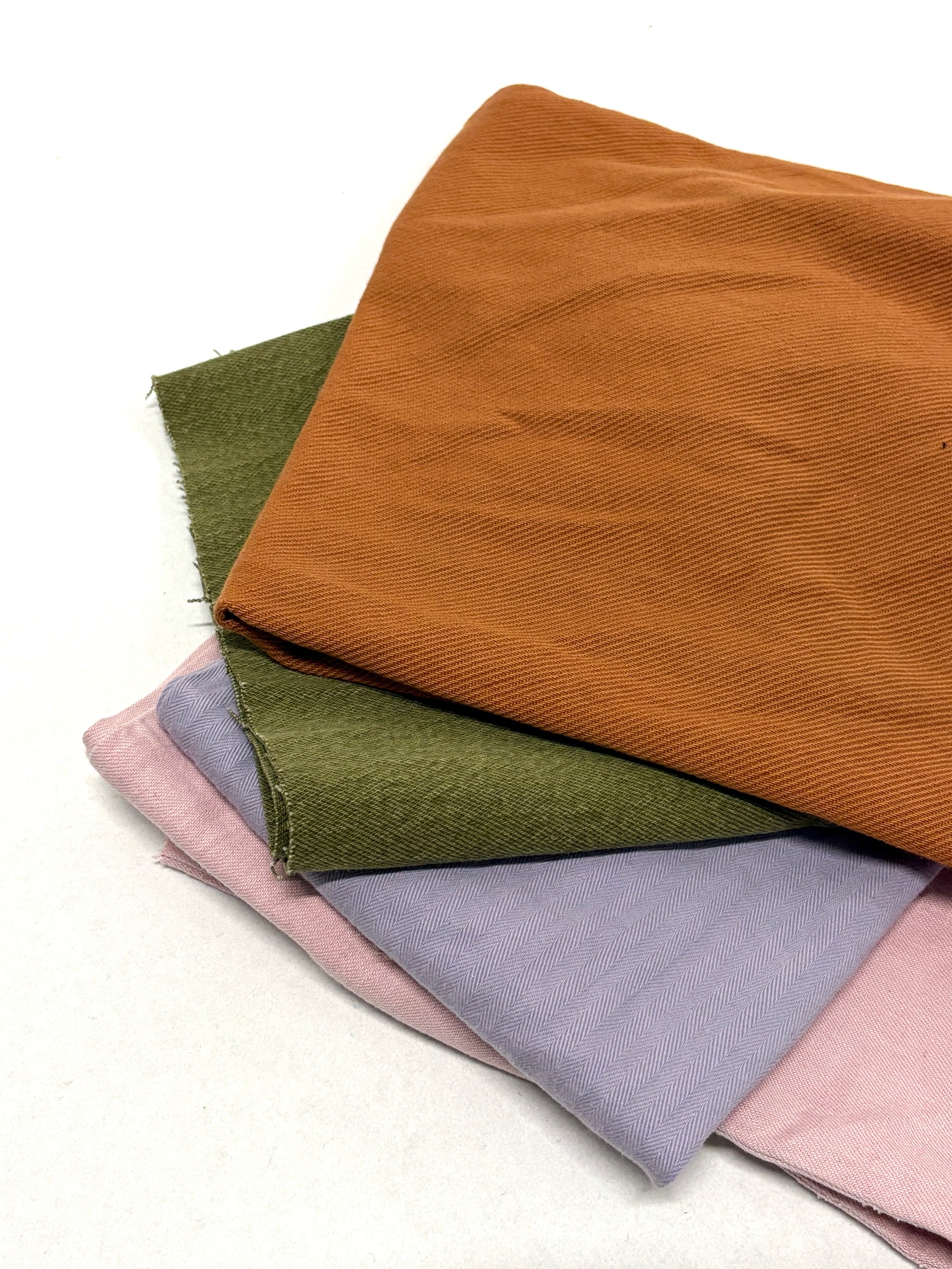 Stack of denim fabric samples in various colours 