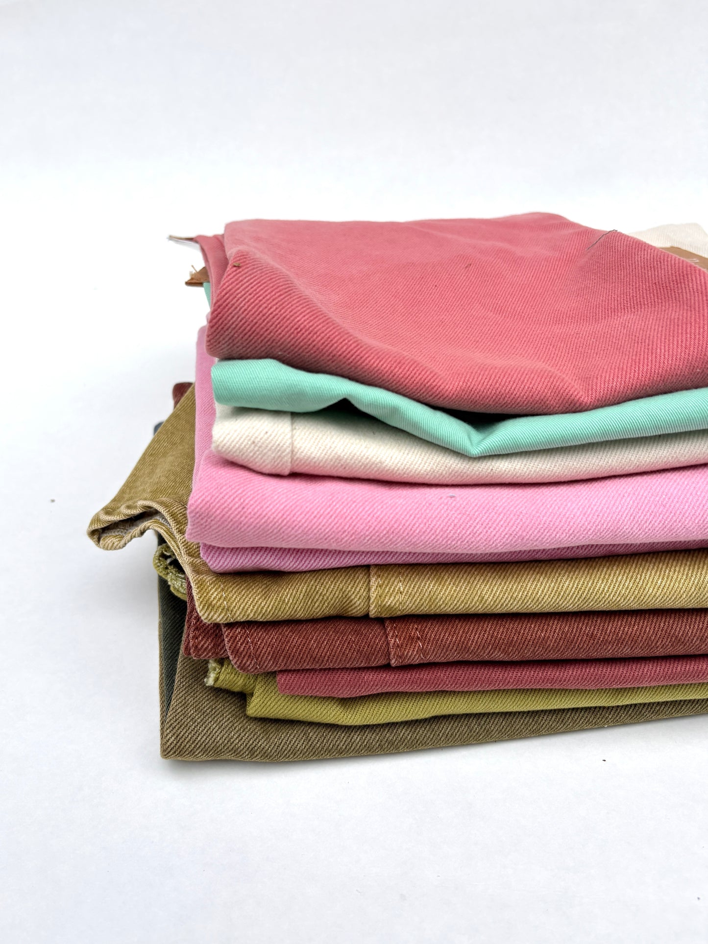 Stack of denim fabric samples in various colours 