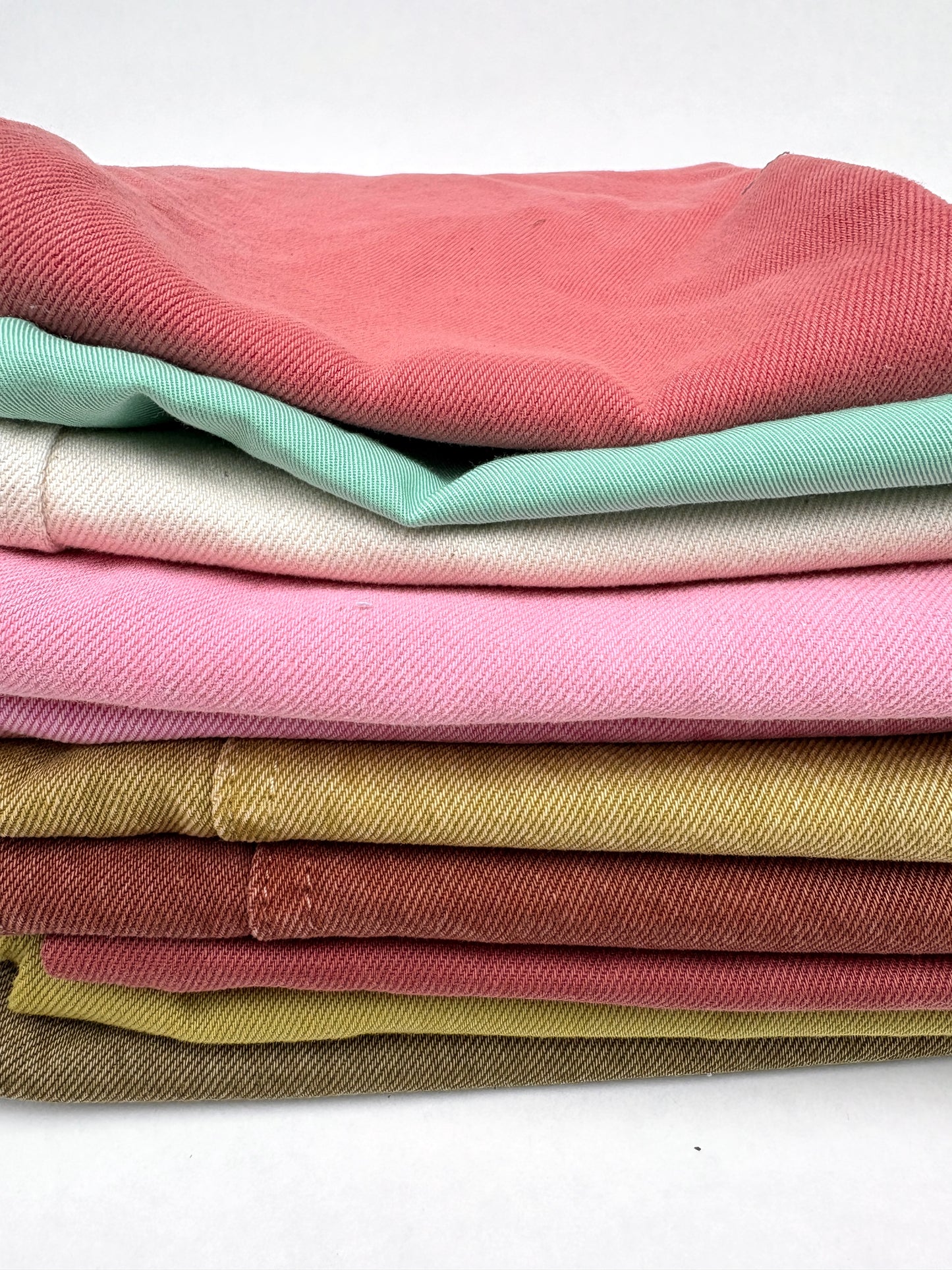 Stack of denim fabric samples in various colours 