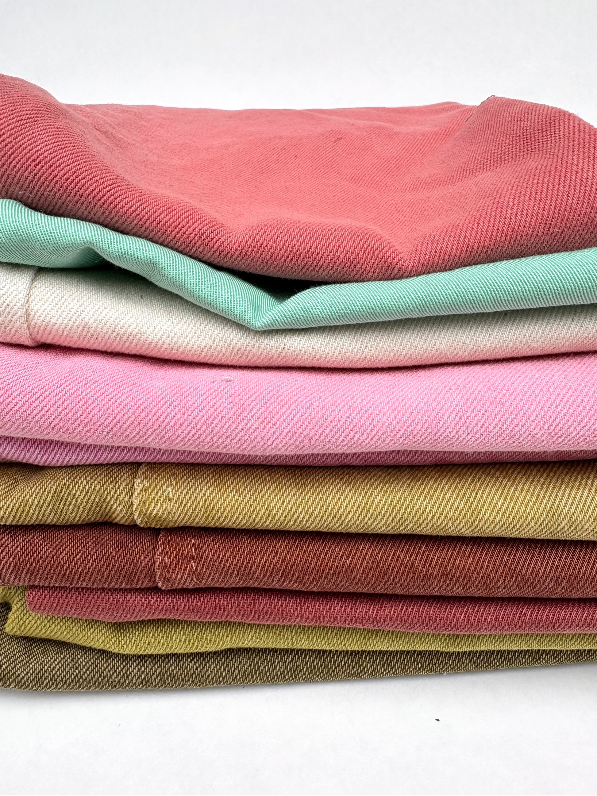 Stack of denim fabric samples in various colours 