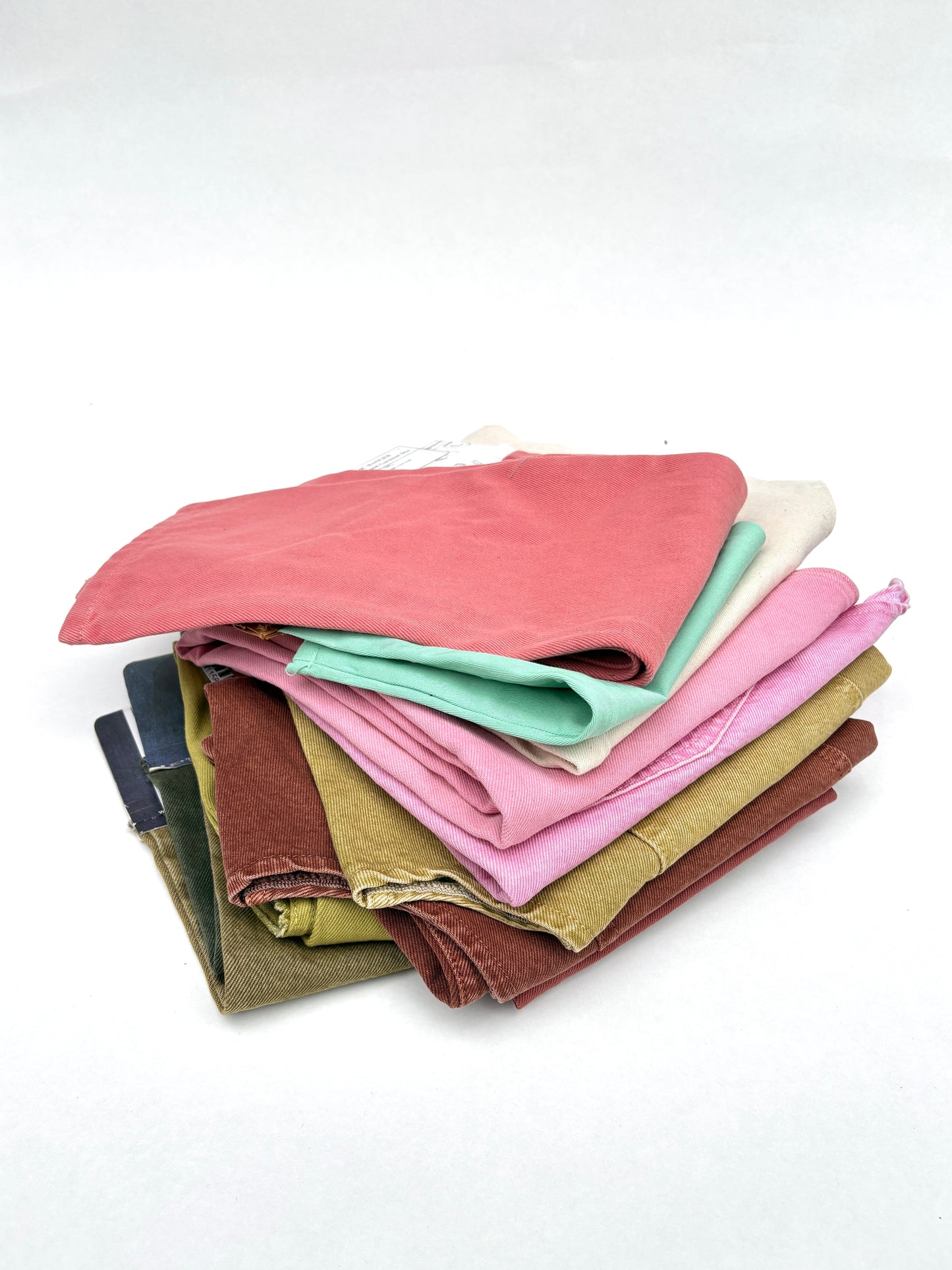 Stack of denim fabric samples in various colours 