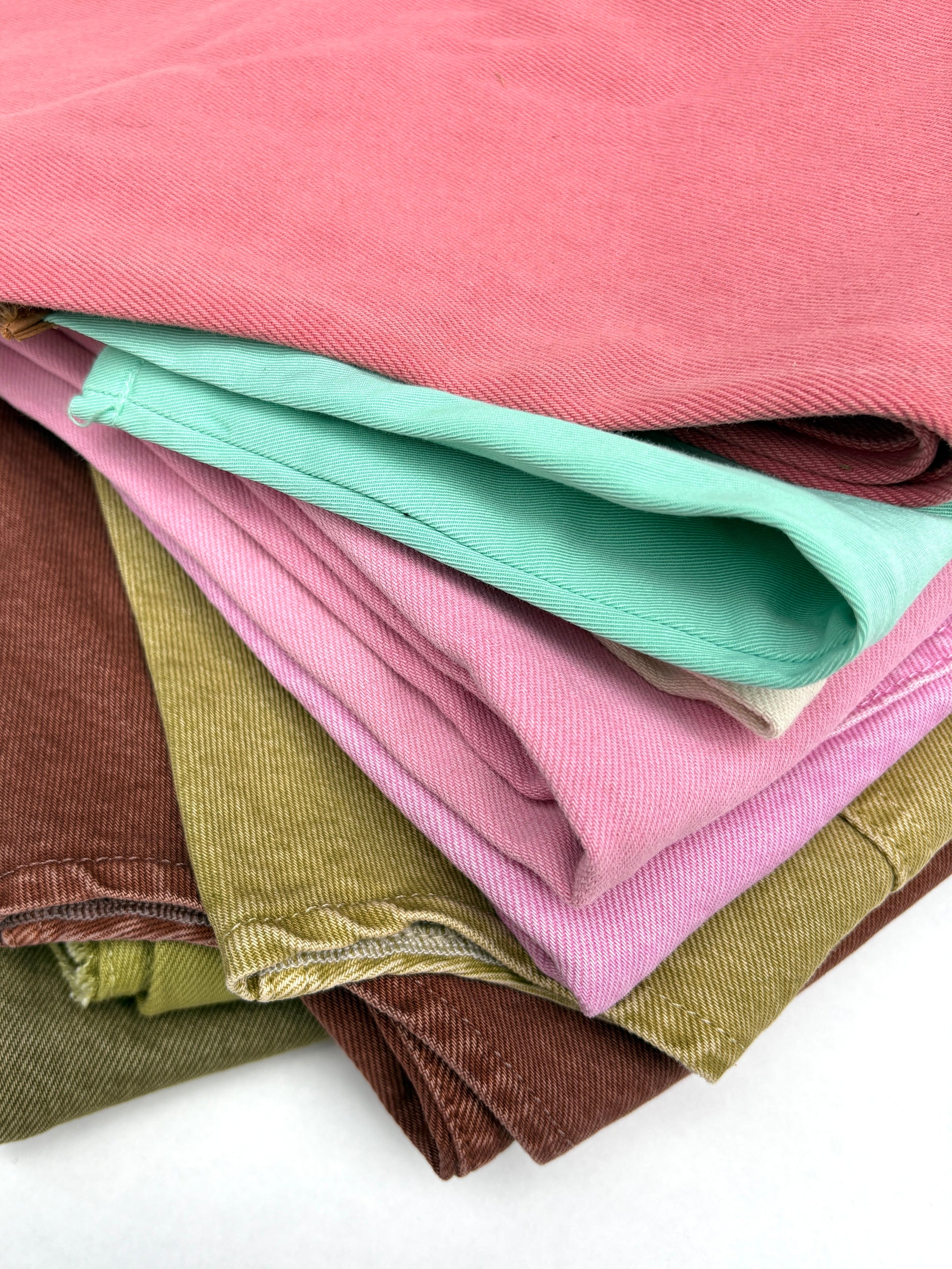 Stack of denim fabric samples in various colours 