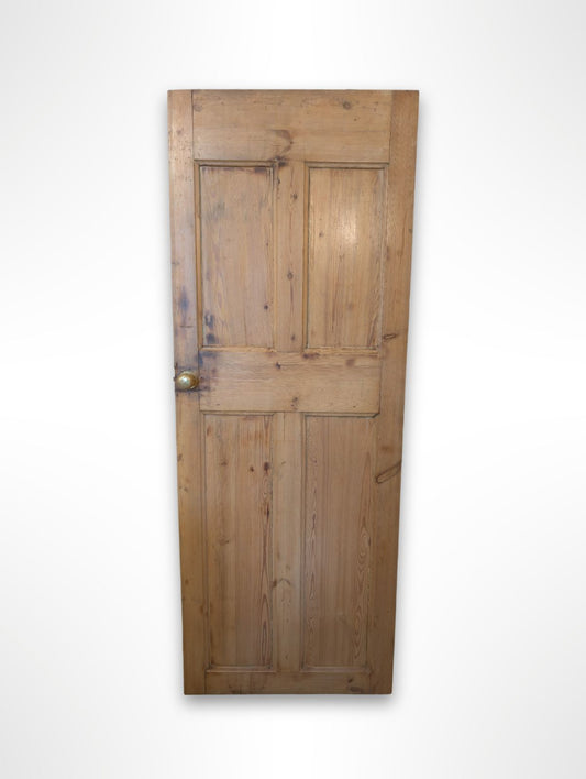 An old pine door with a dark stain, featuring a handle, showing natural ageing patterns