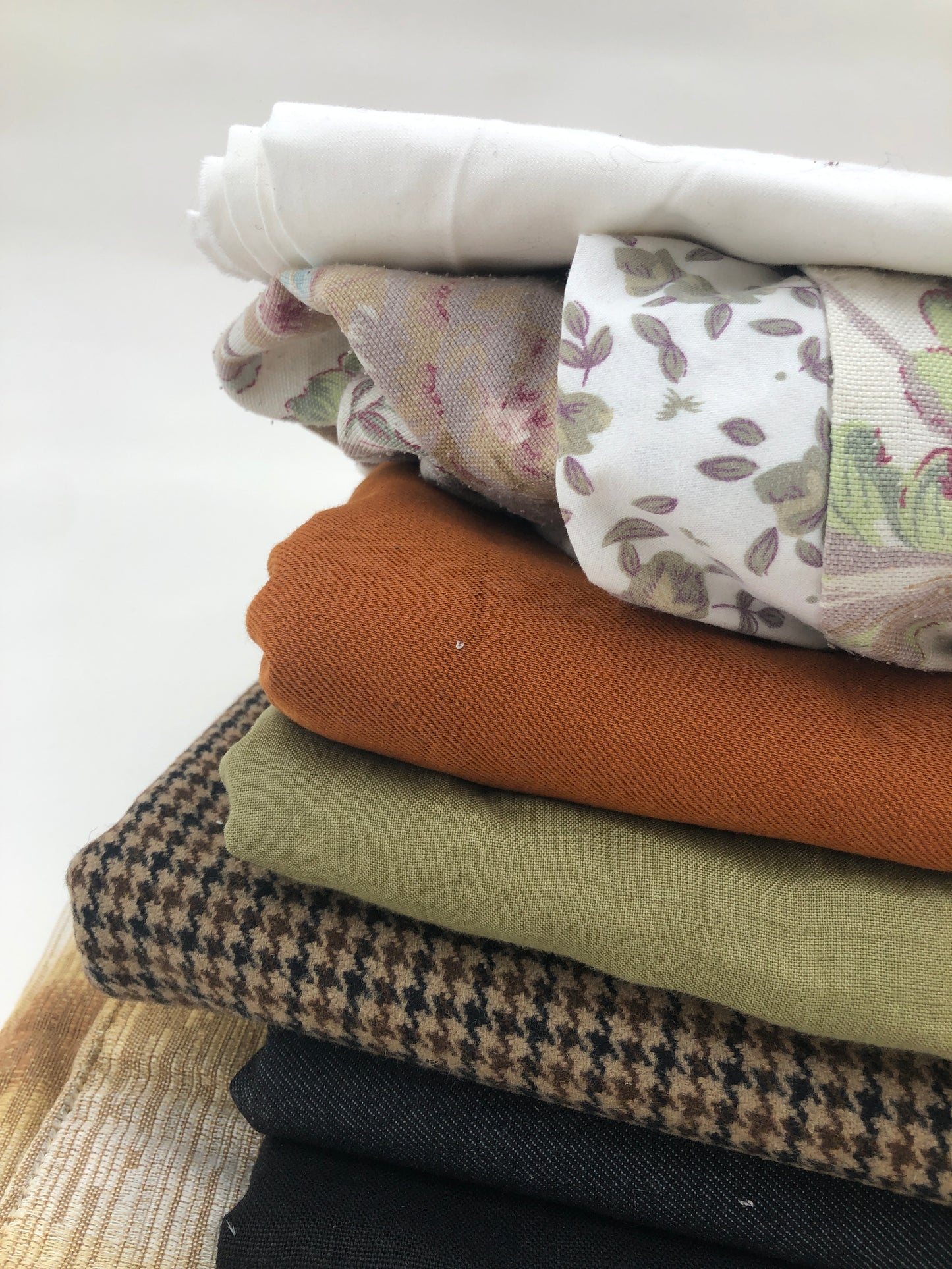 Stack of large pieces of earthy-coloured fabrics 
