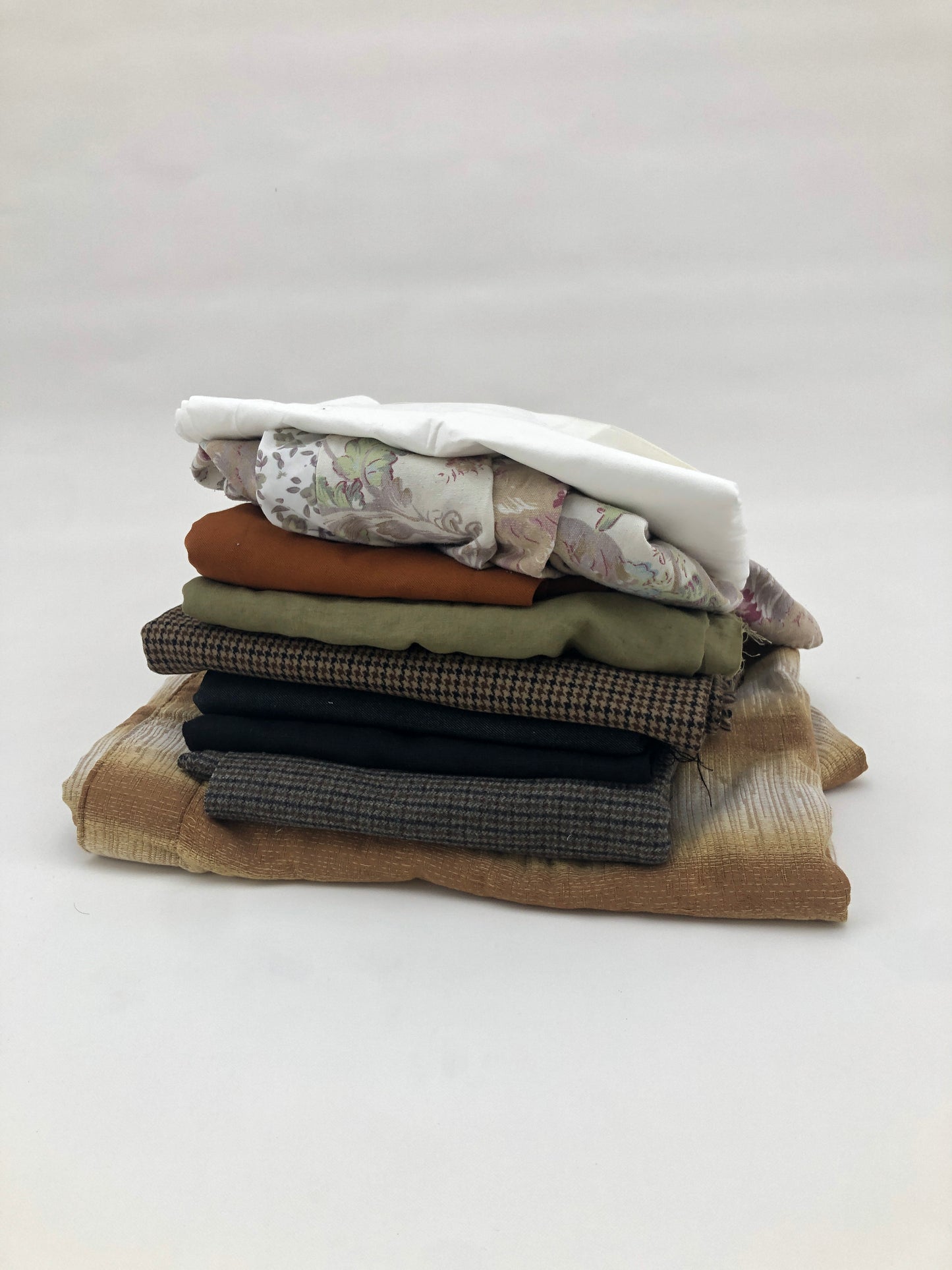 Stack of large pieces of earthy-coloured fabrics 