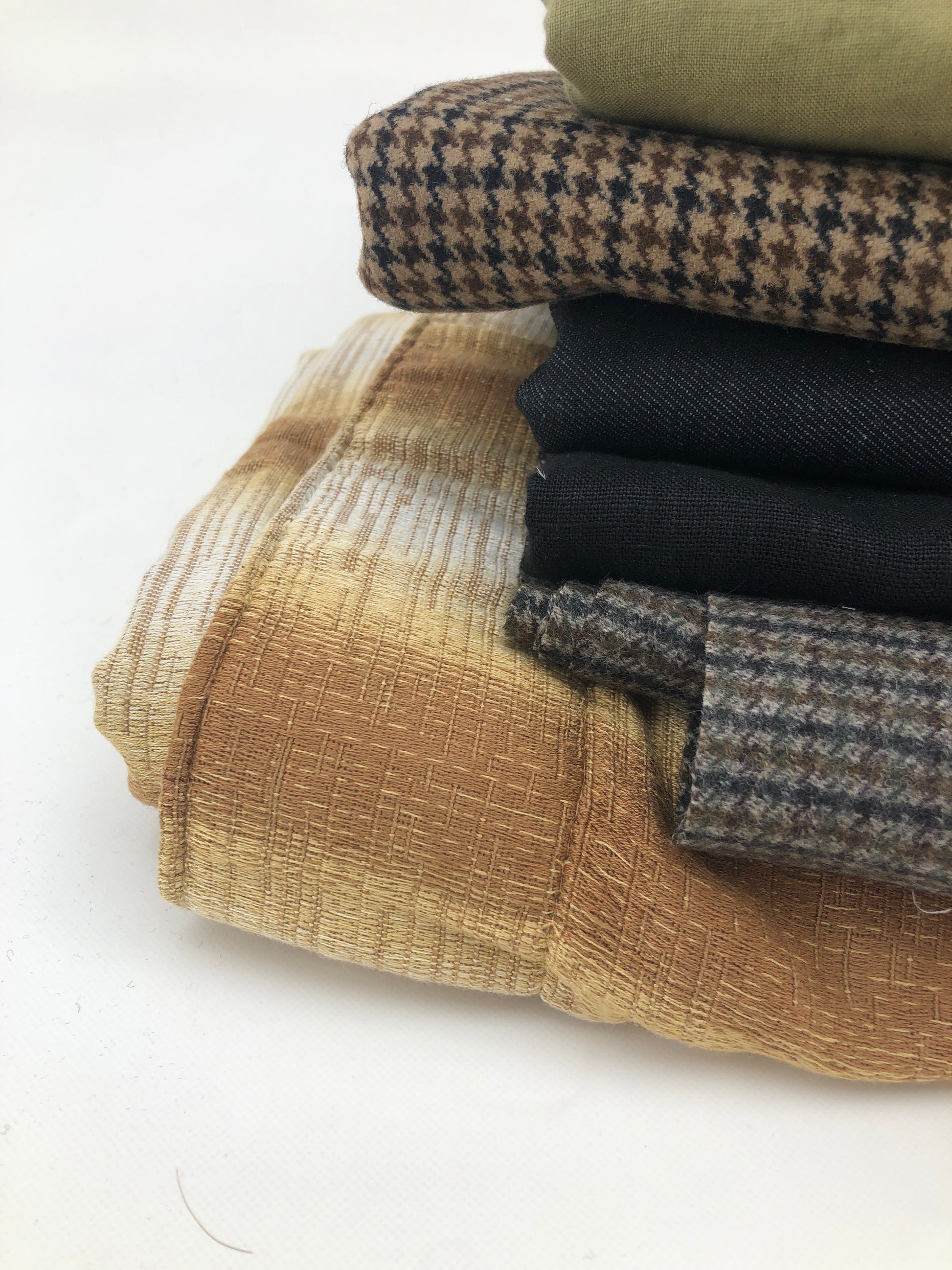 Stack of large pieces of earthy-coloured fabrics 