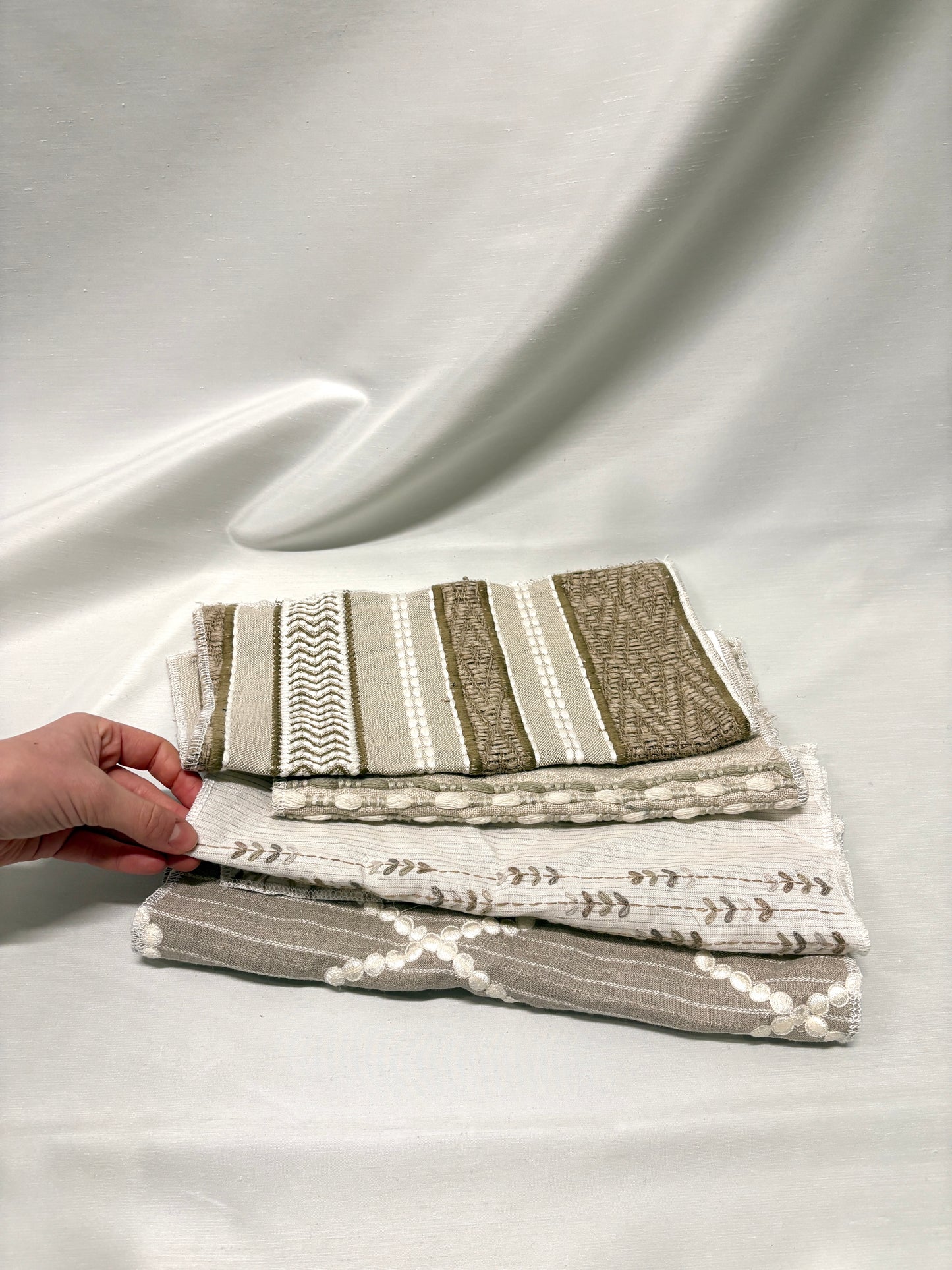 Stack of embroidered fabric with various patterns and colours 