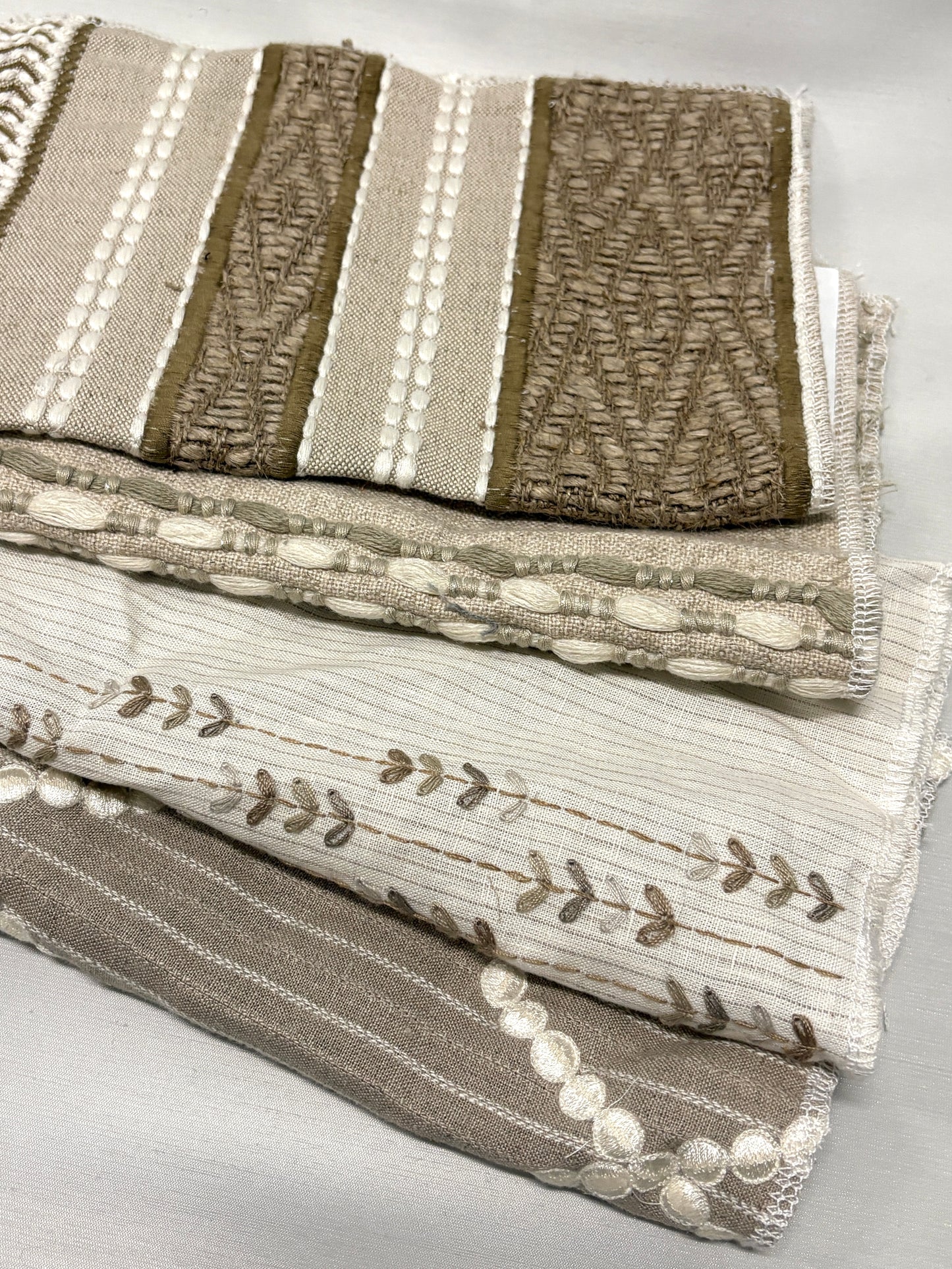 Stack of embroidered fabric with various patterns and colours 