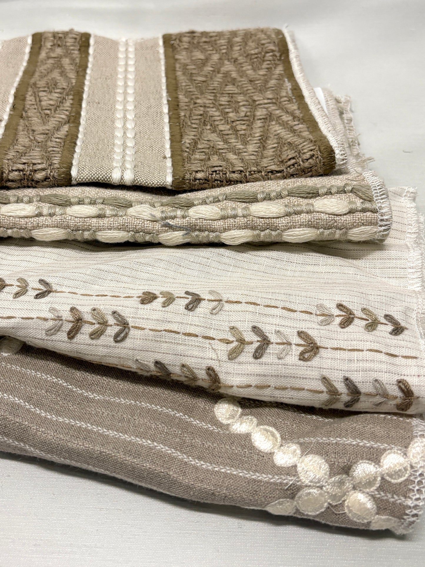 Stack of embroidered fabric with various patterns and colours 