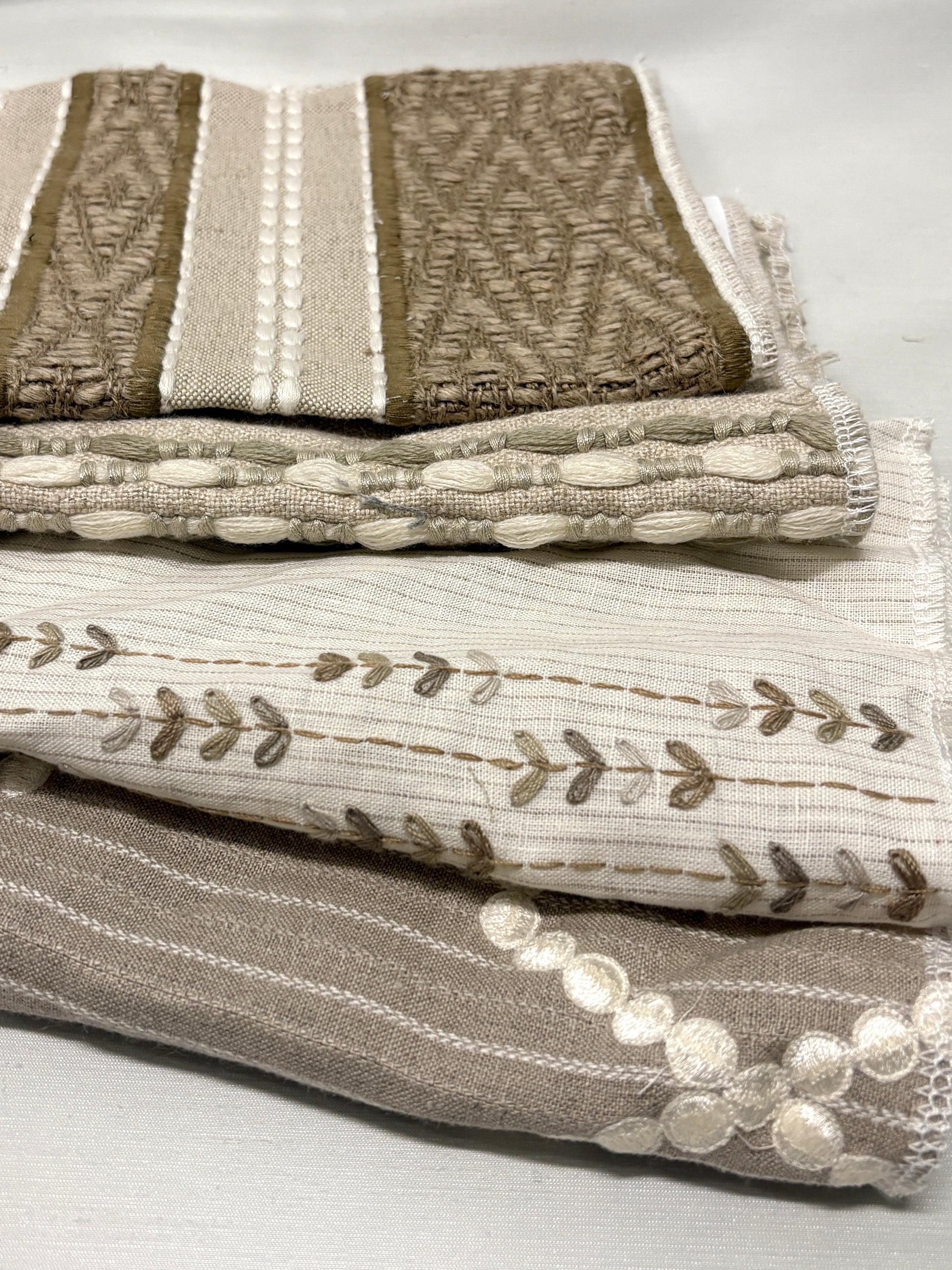 Stack of embroidered fabric with various patterns and colours 