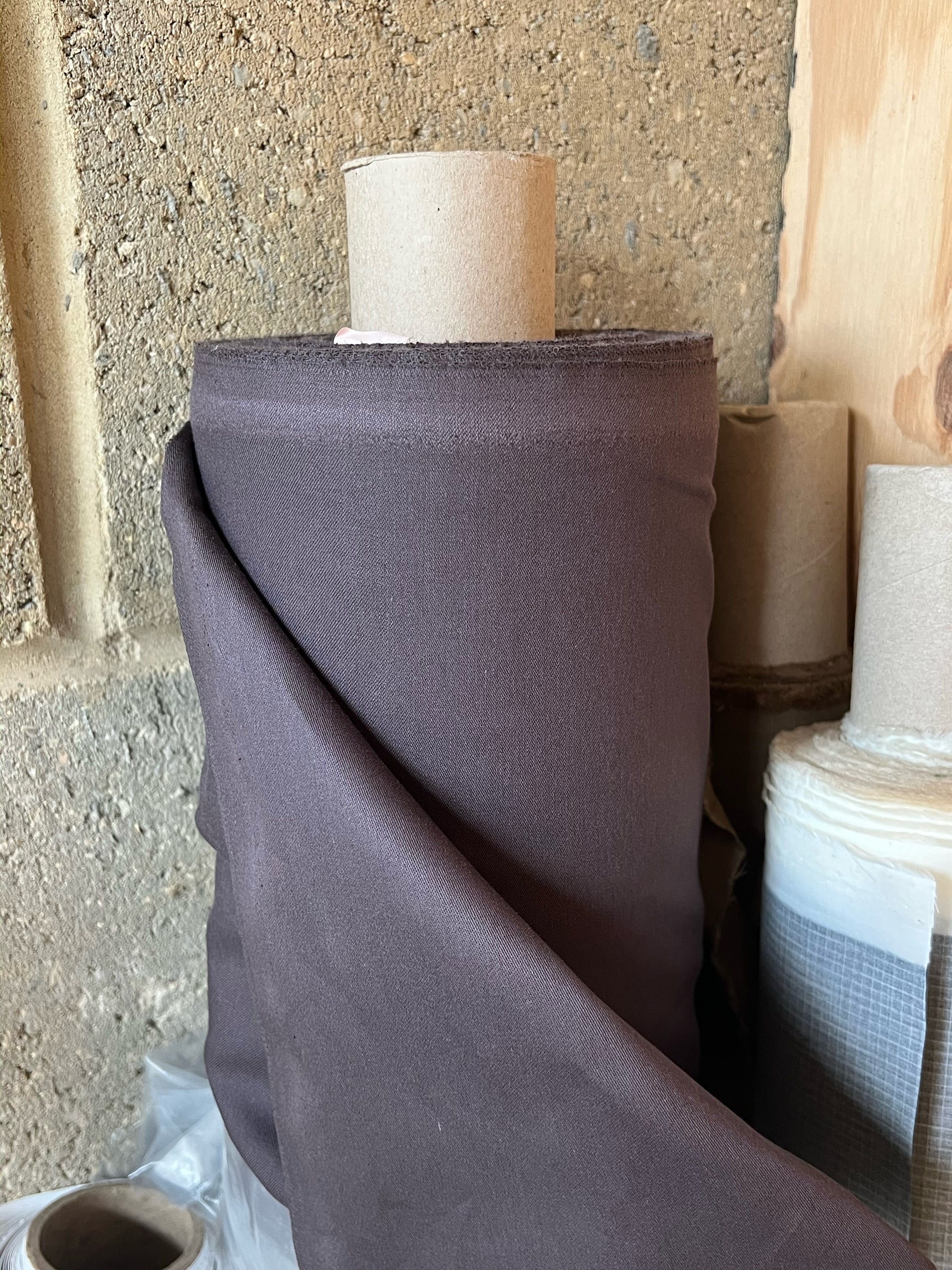 Roll of organic cotton satin fabric in chocolate brown