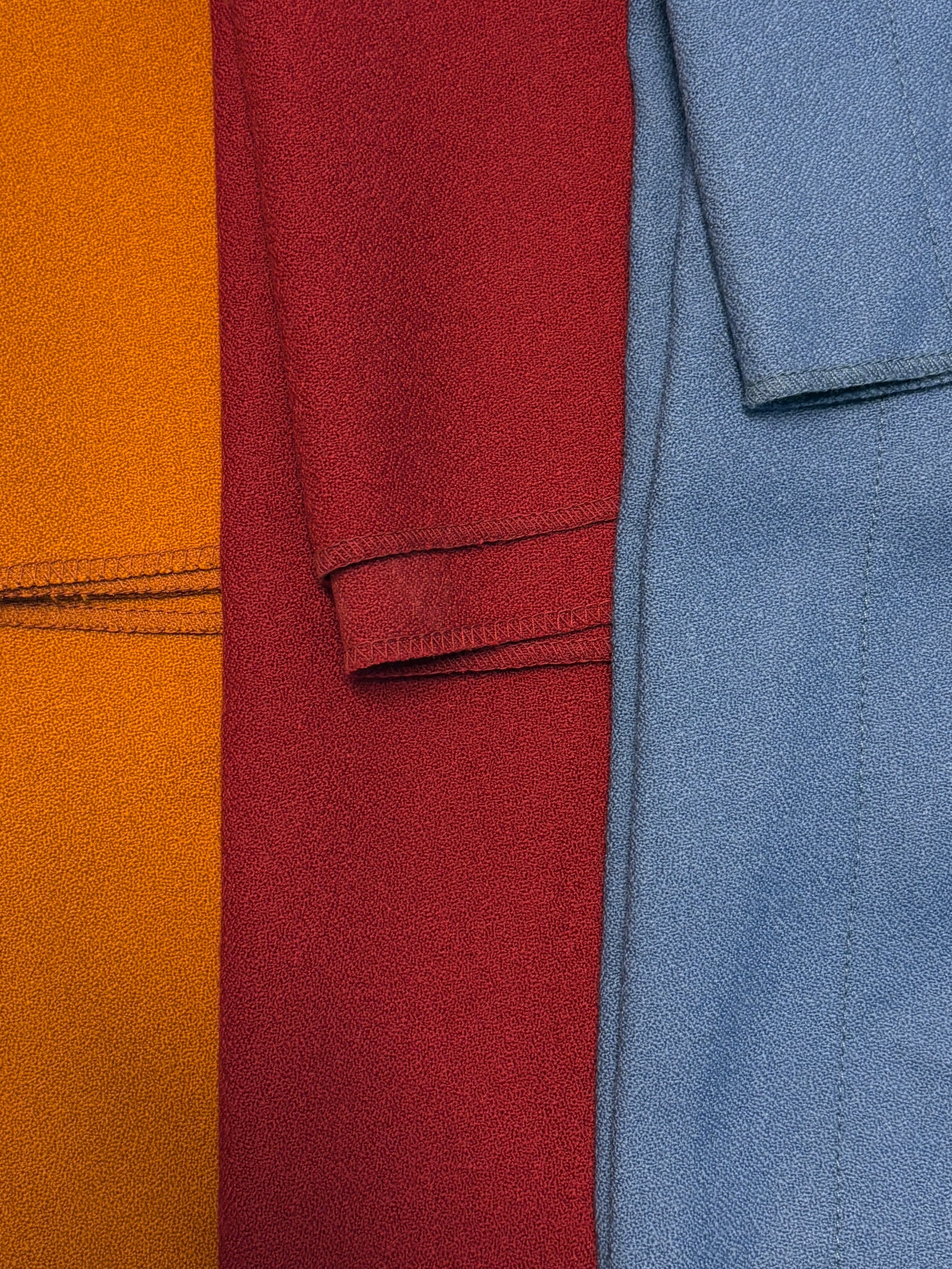 Close-up of folded wool crepe fabric in blue, yellow, and red 