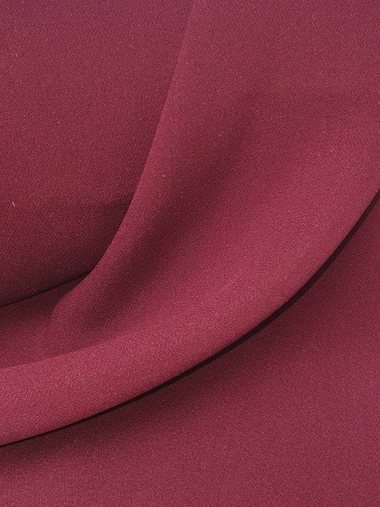 Close-up of light weighted fabric in burgundy, soft texture visible 