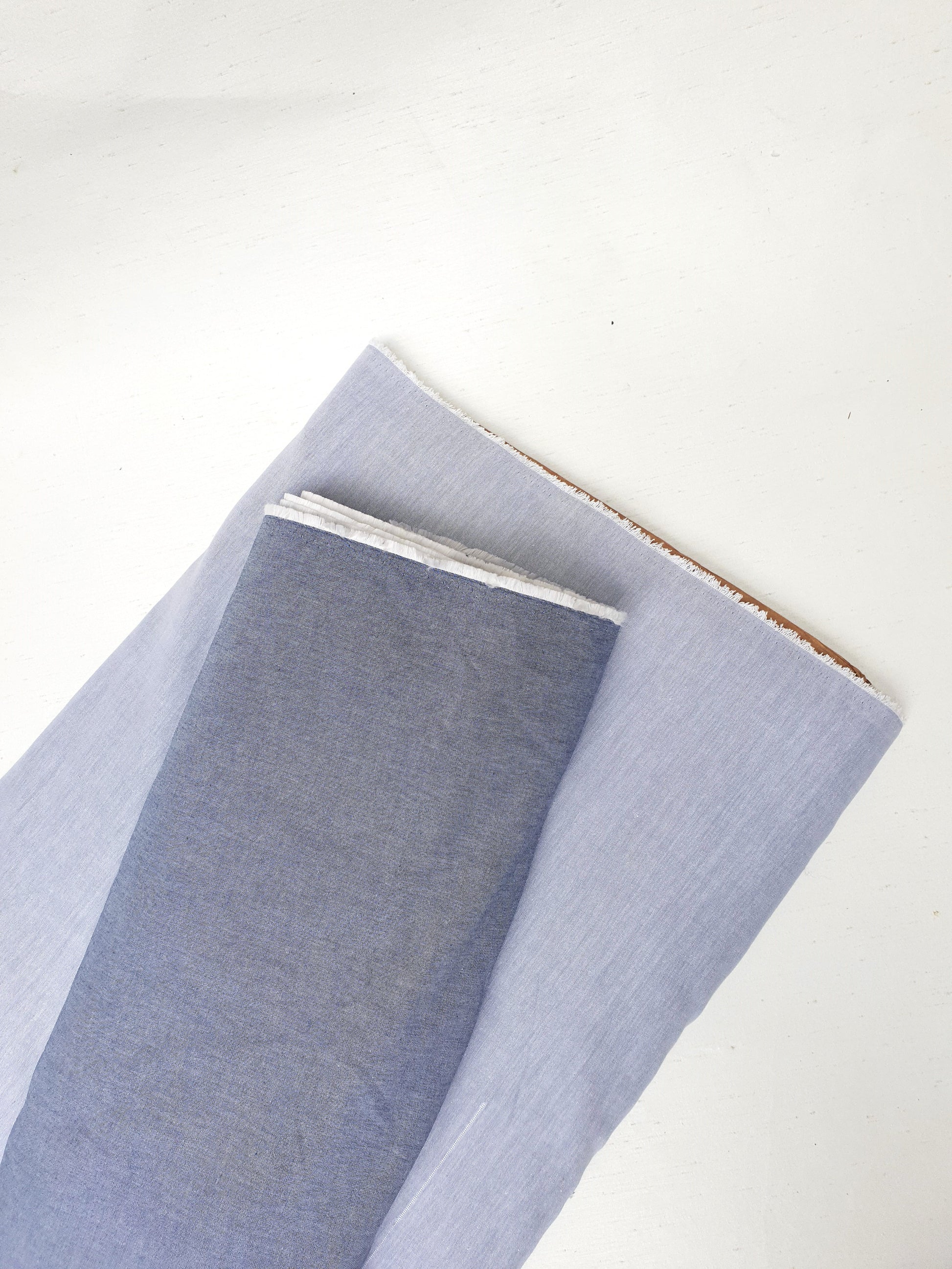 Two rolls of chambray cotton fabric in blue-grey