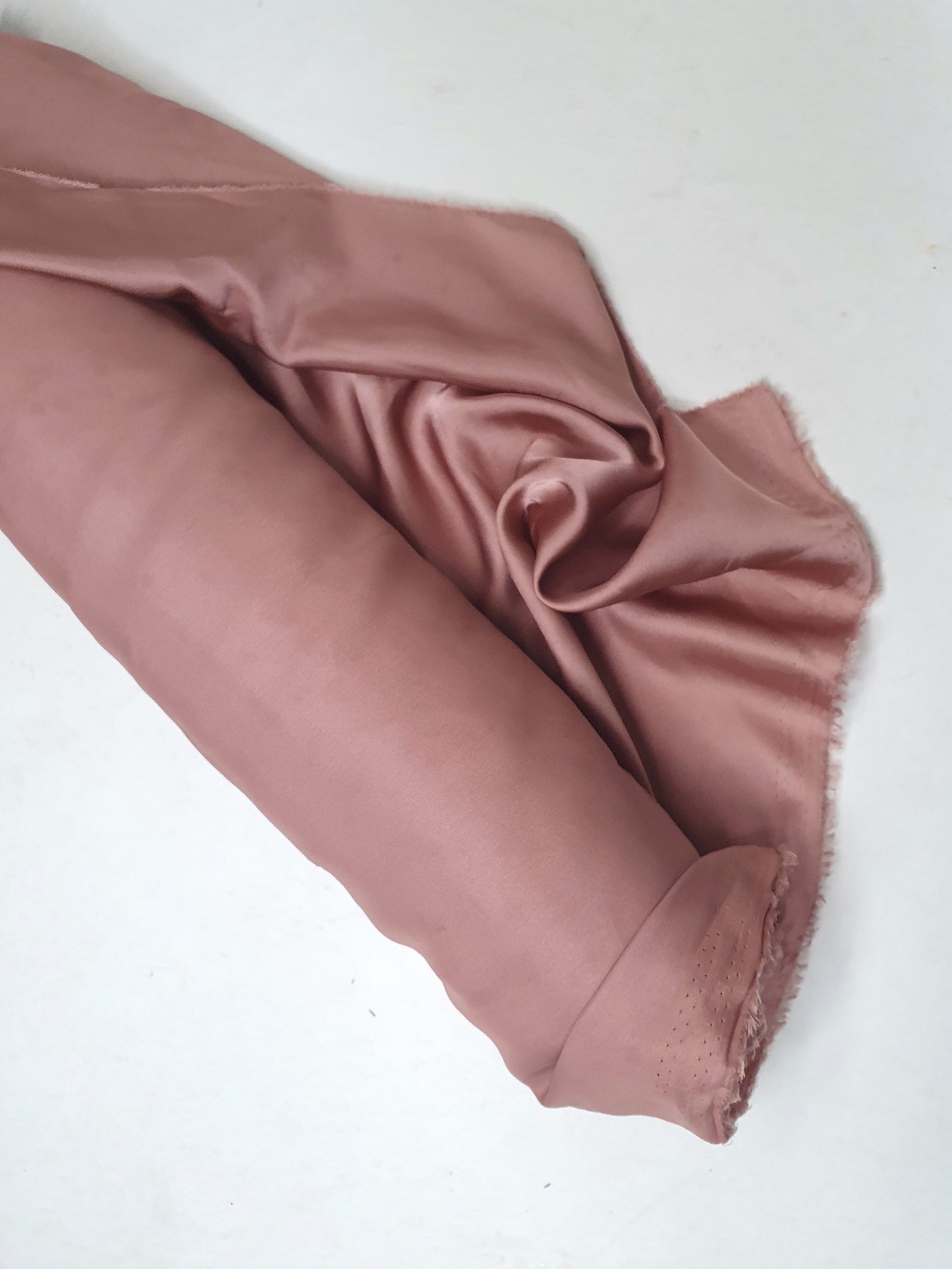 Charmeuse fabric in pink, shiny texture visible 