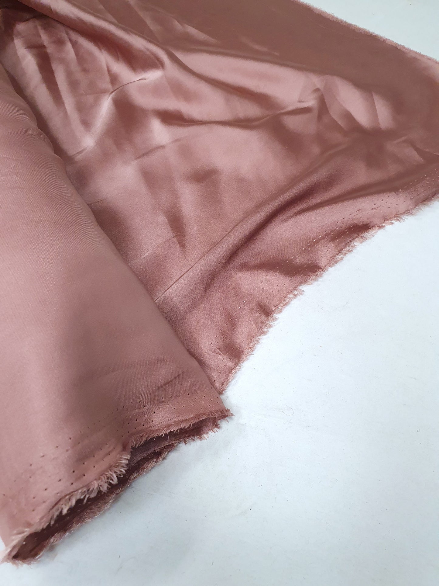 Charmeuse fabric in pink, shiny texture visible 