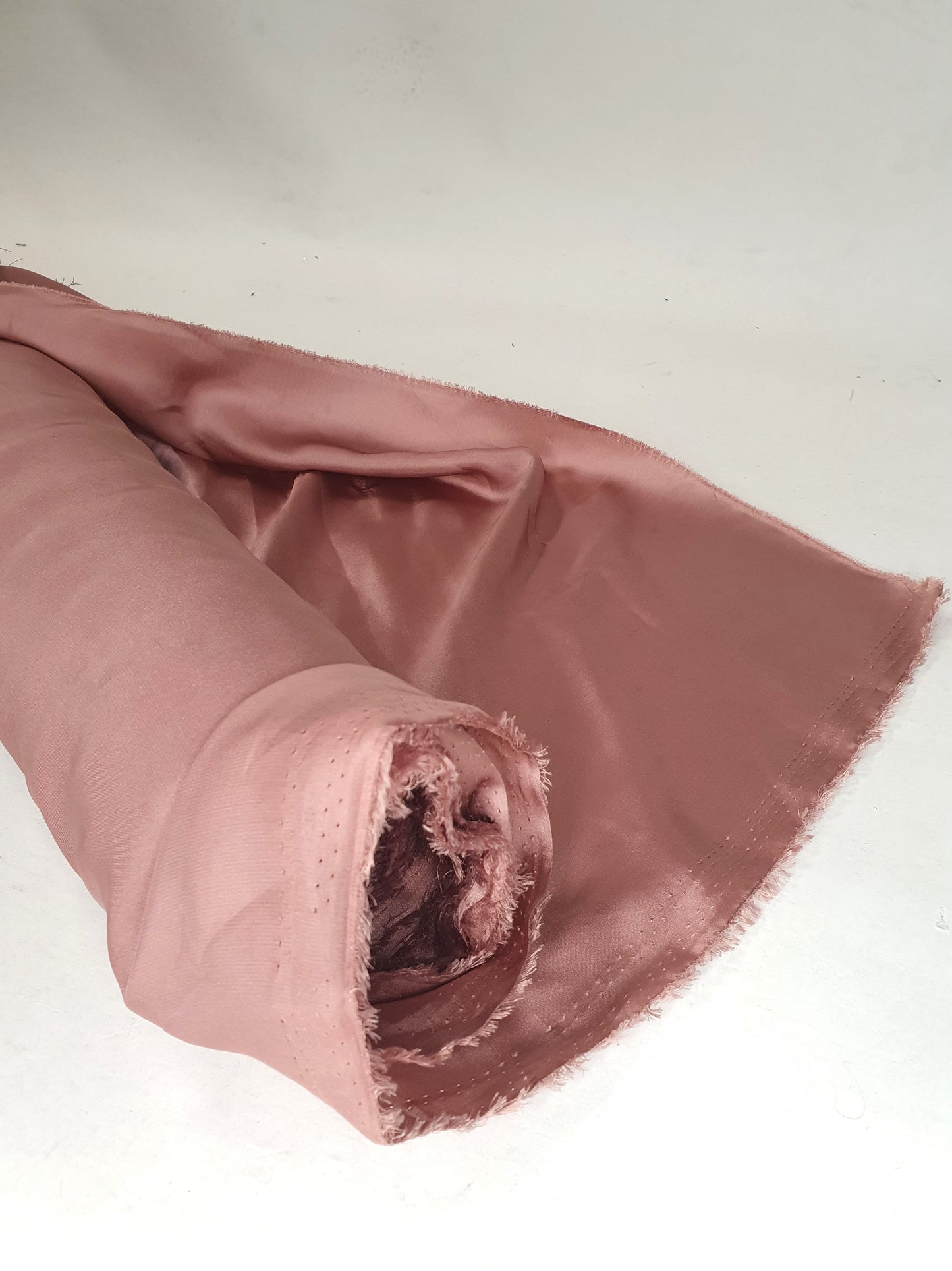 Charmeuse fabric in pink, shiny texture visible 